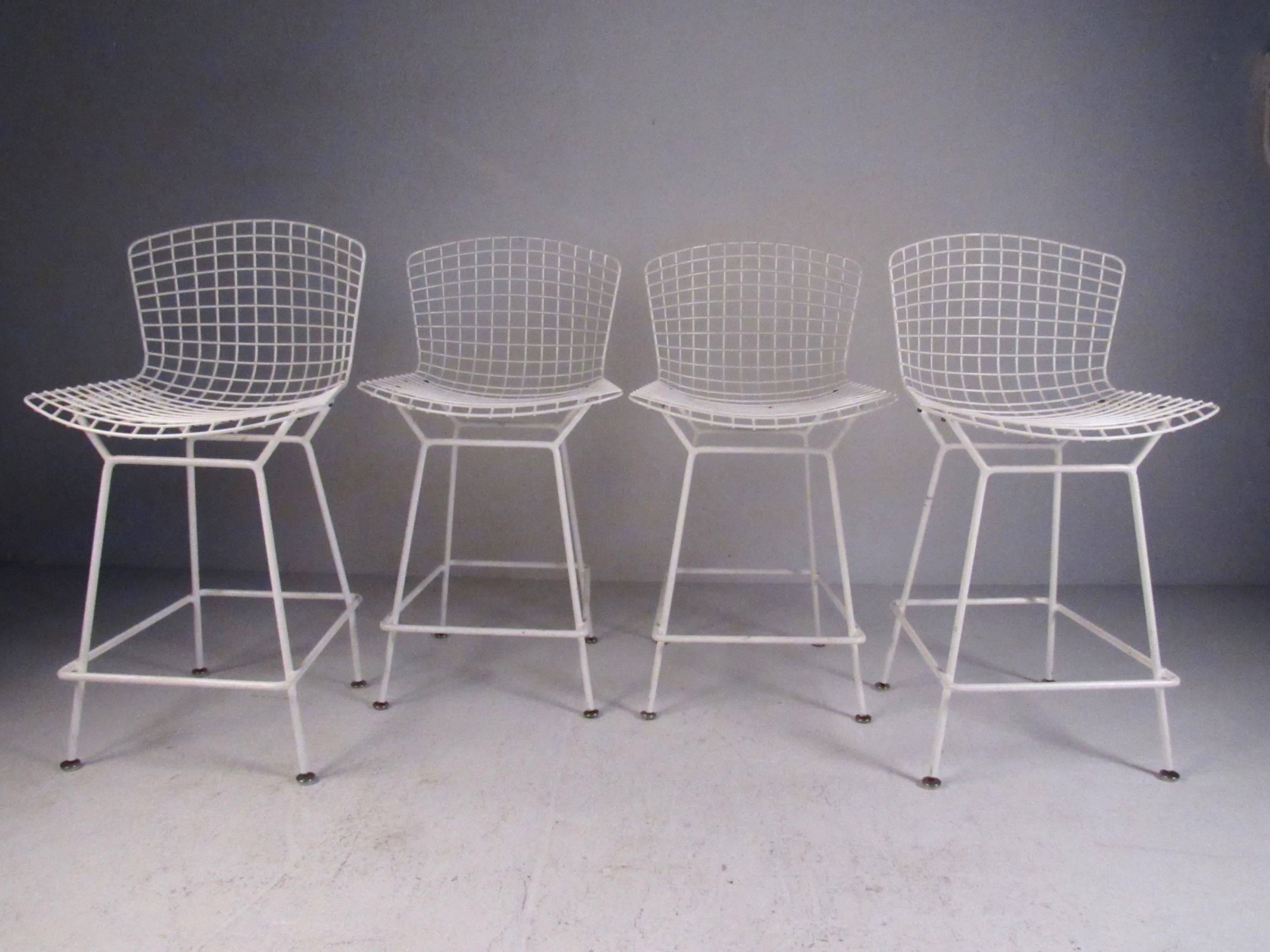 This stylish set of four Mid-Century bar stools as designed by Harry Bertoia for Knoll International, circa 1970s. Stunning modern design includes sculpted wire seat and sturdy footrest. Please confirm item location (NY or NJ).