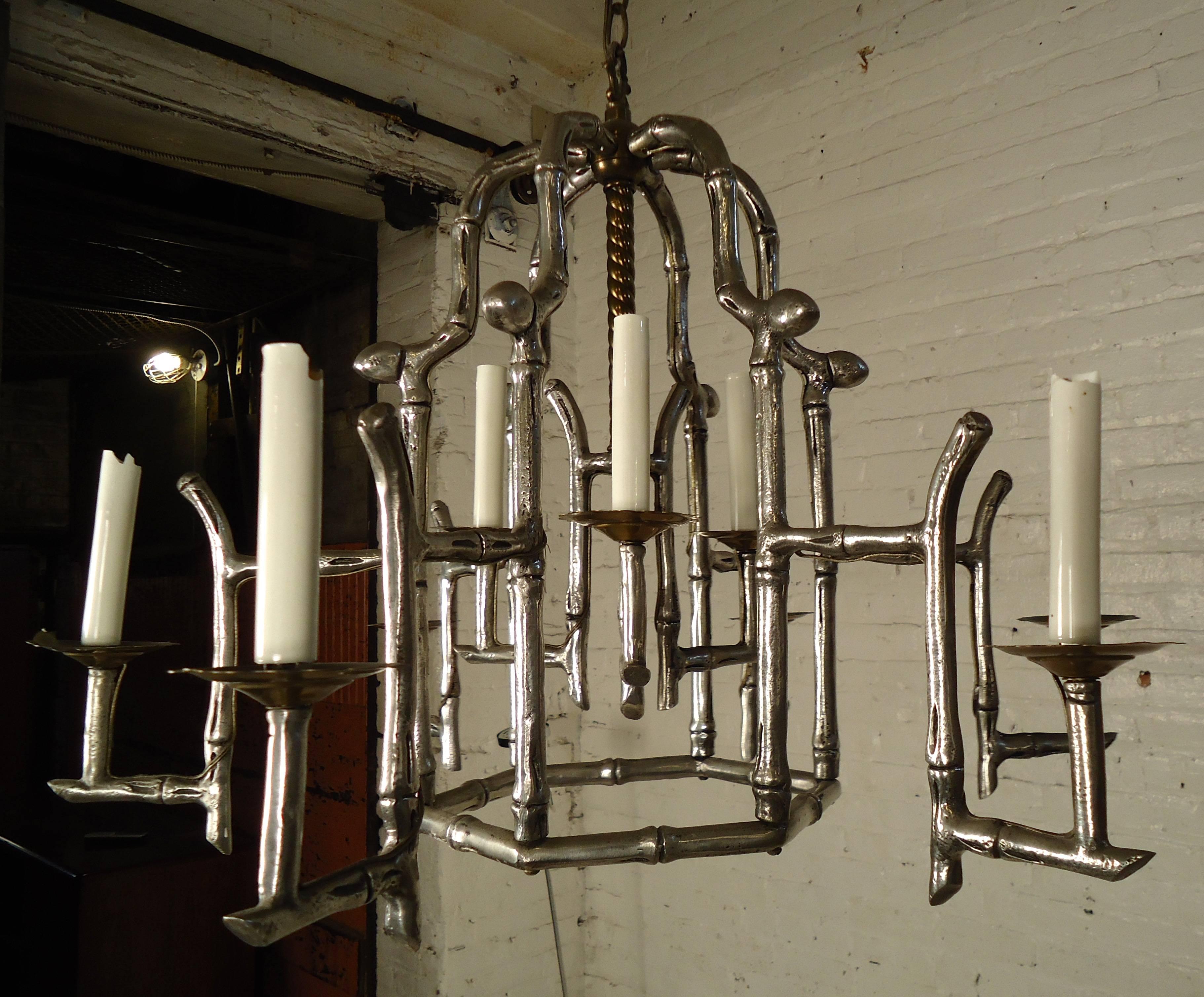 Very unique Mid-Century Modern silver faux bamboo chandelier features imitation candlestick lighting hanging from a spiral center rod equipped with a chain.

(Please confirm item location - NY or NJ - with dealer).