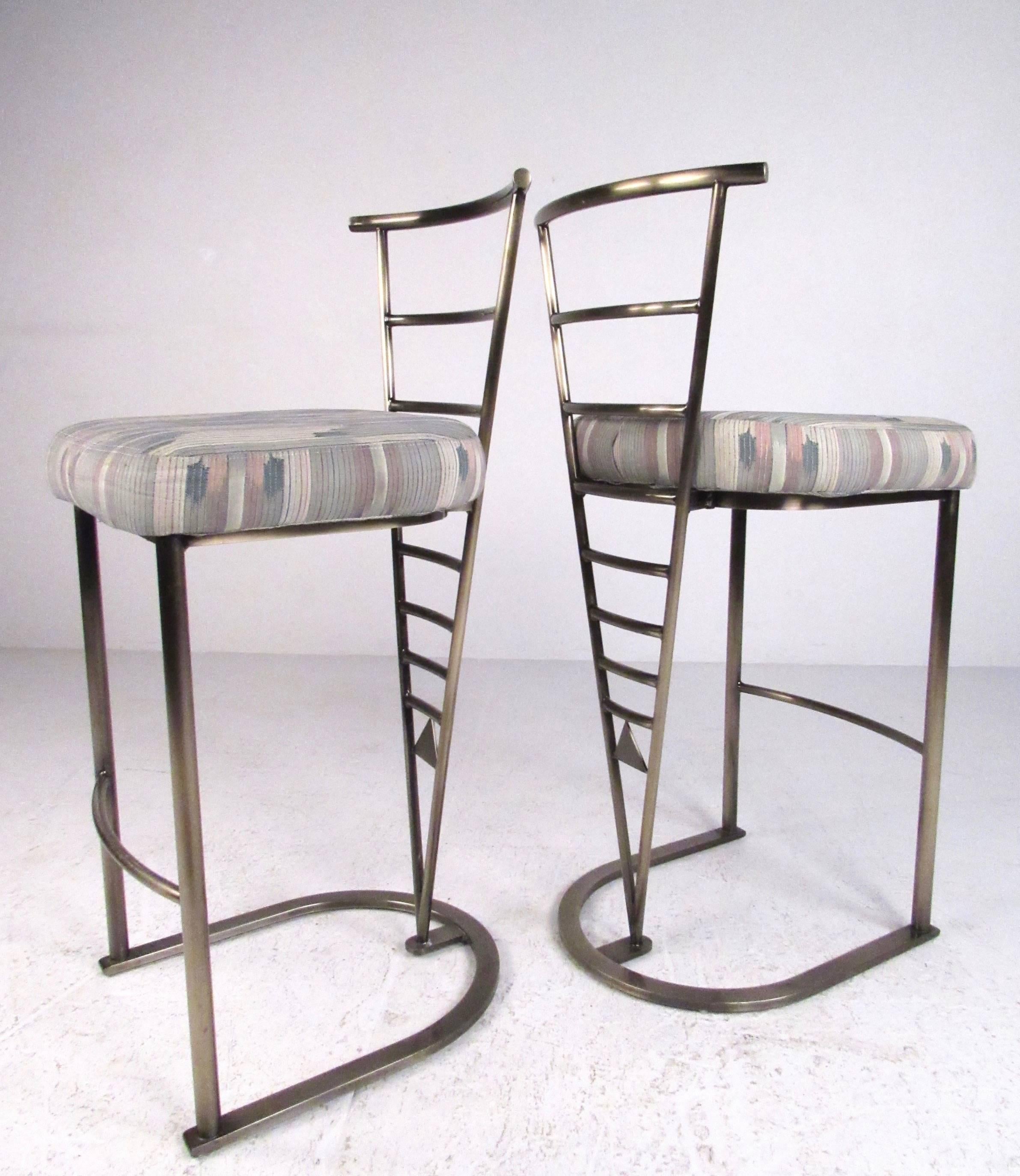This stylish pair of bar stools by Design Institute of America feature sturdy metal frames with plush upholstered seats. Sculptural design adds modern flare to any bar setting, please confirm item location (NY or NJ).