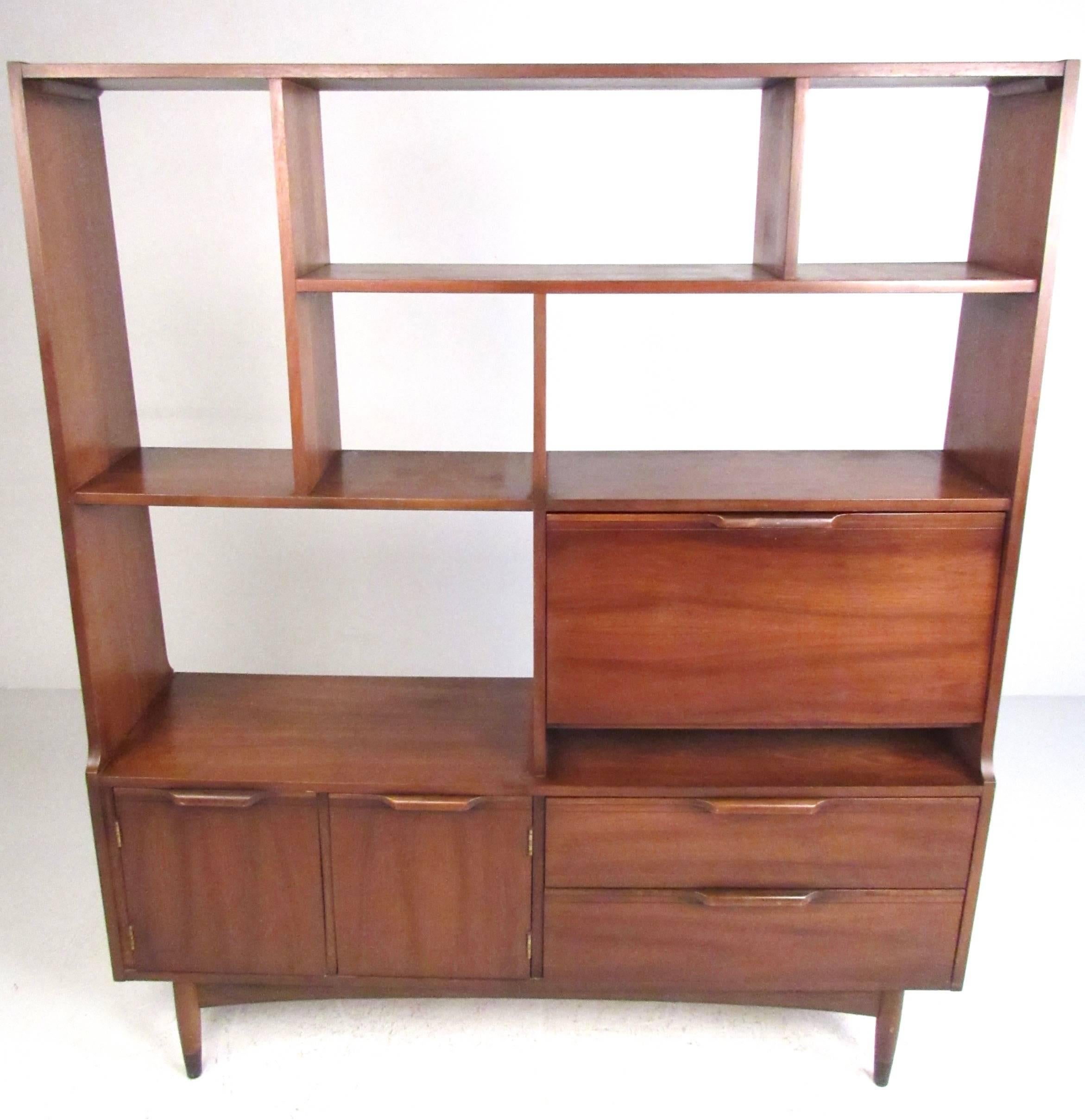 This stylish walnut bookshelf features an array of storage options including drop front writing desk, open cabinet space, and open shelf storage. Finished back makes this impressive piece an ideal room divider or wall unit, offering creative display