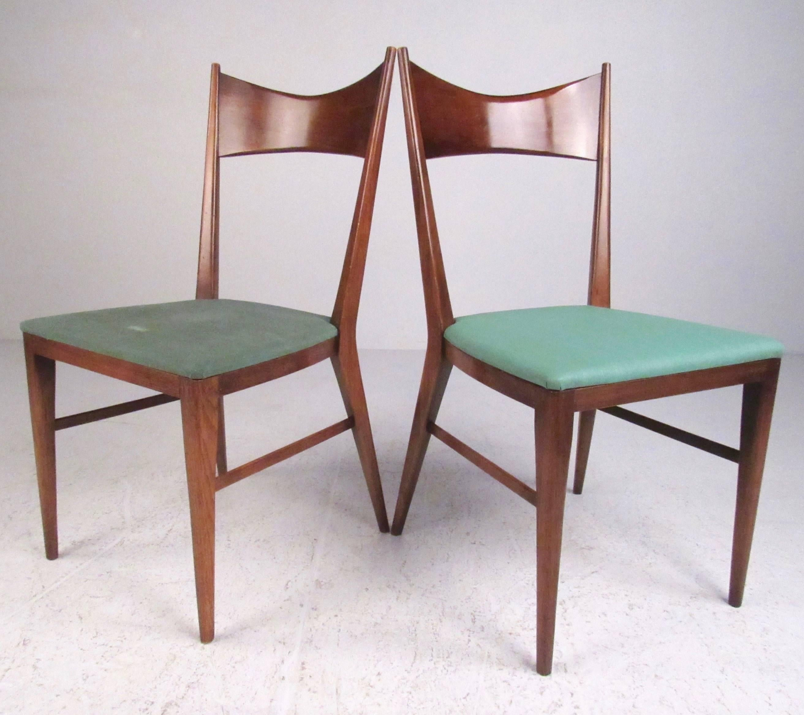 This stylish pair of Paul McCobb dining chairs feature's sculpted walnut frames with contoured seat backs and tapered legs. Rich original finish is the perfect compliment to Mid-Century design, original manufacturer's mark on the bottom. Please