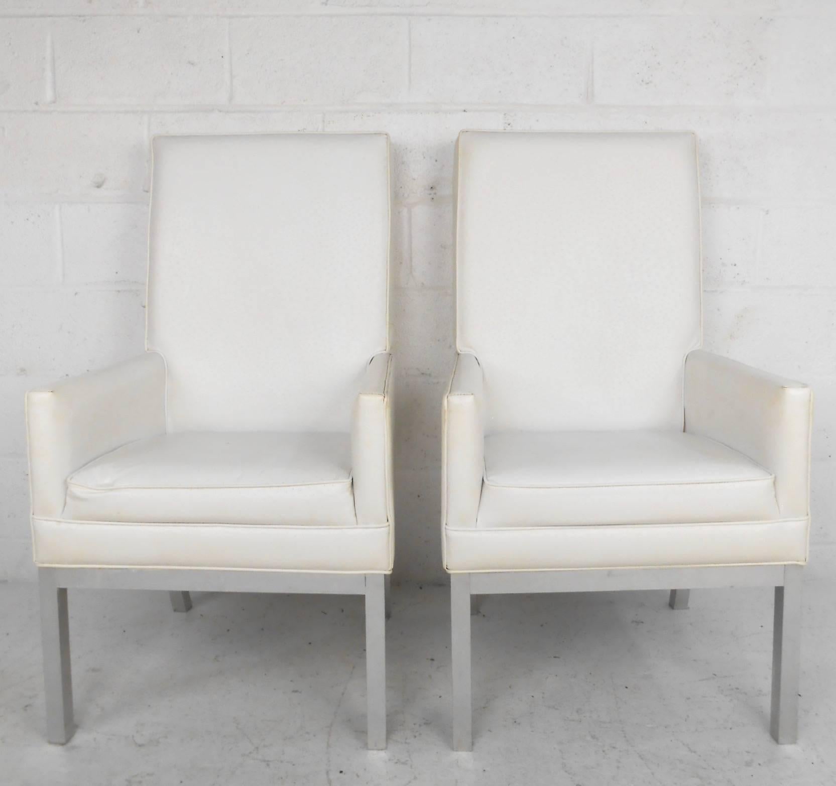 Dieses einzigartige Paar gepolsterter Sessel mit hoher Rückenlehne hat einen Rahmen aus gebürstetem Aluminium und einen gepolsterten Vinylbezug. Das elegante Paar bietet bequeme Proportionen und eine attraktive, moderne Form in jeder Umgebung. Bitte