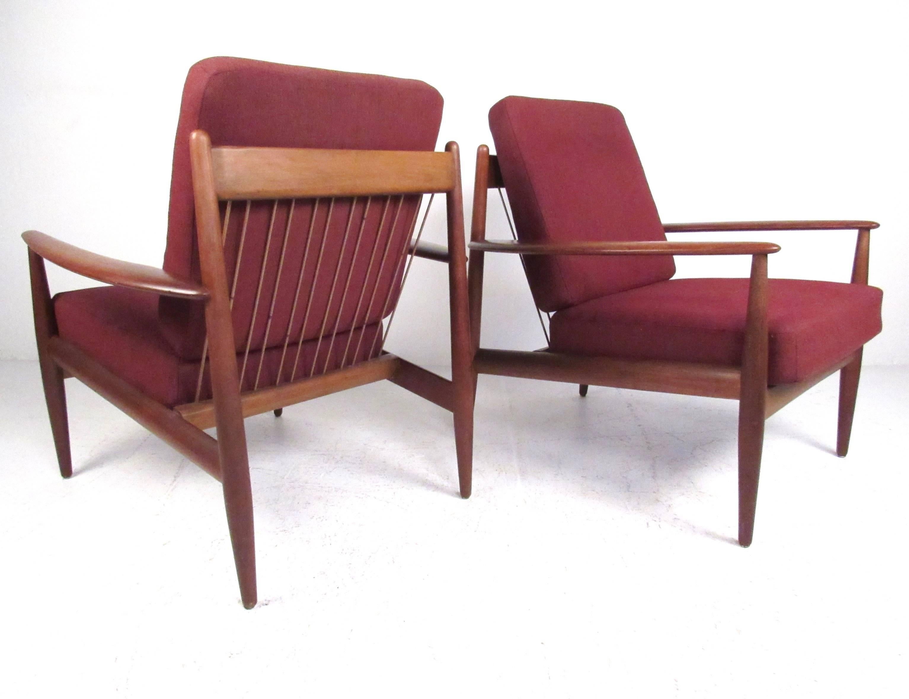 This stylish pair of Danish modern lounge chairs feature sculptural teak frames with plush upholstered cushions. Designed by Grete Jalk for France & Daverkosen this Mid-Century pair makes these the perfect addition to home or business. Please