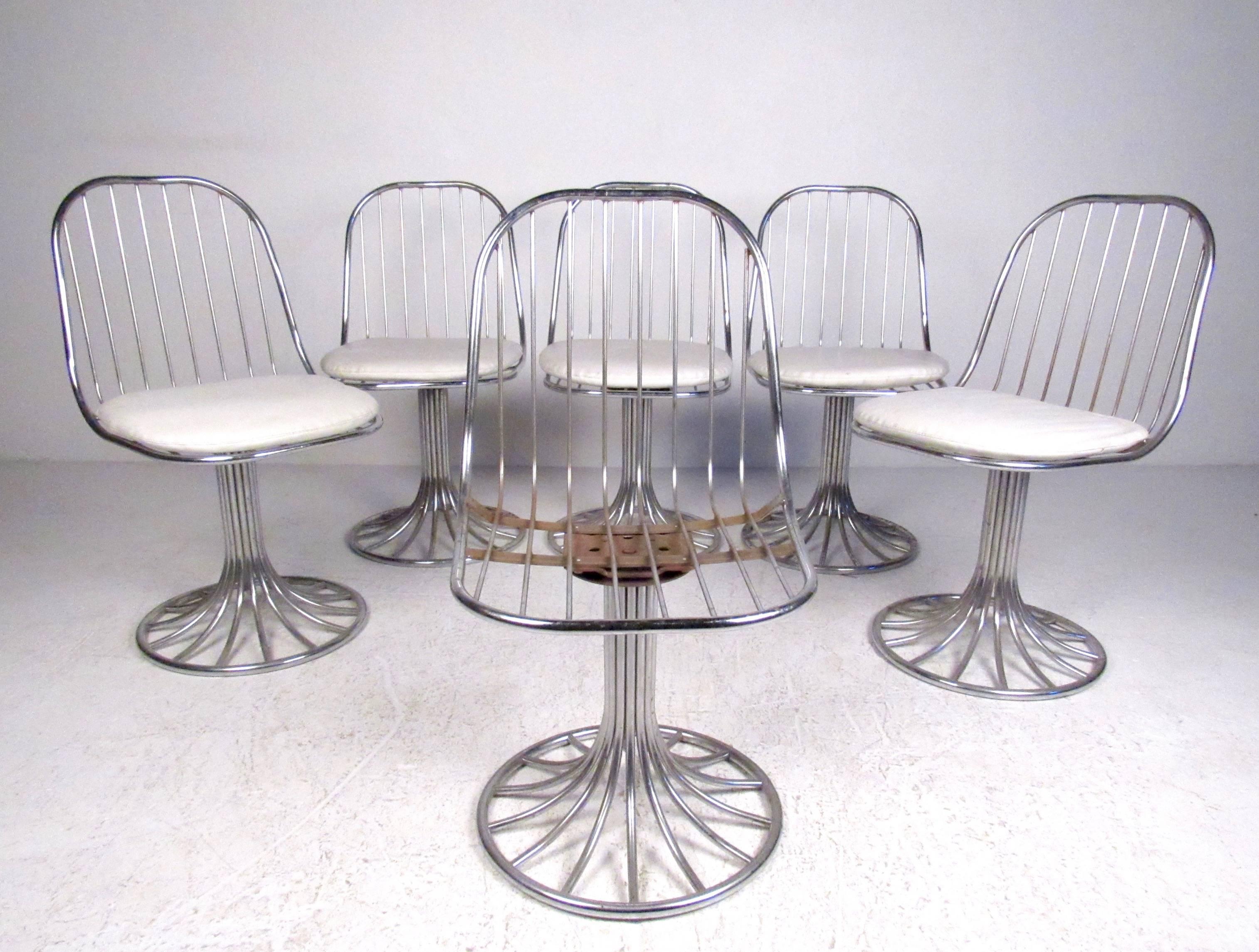 This stylish set of Mid-Century chrome swivel chairs feature unique bent spoke construction, with a tulip pedestal base and shapely seat back. Padded cushion and comfortable proportions make this the perfect set of vintage swivel dining chairs for