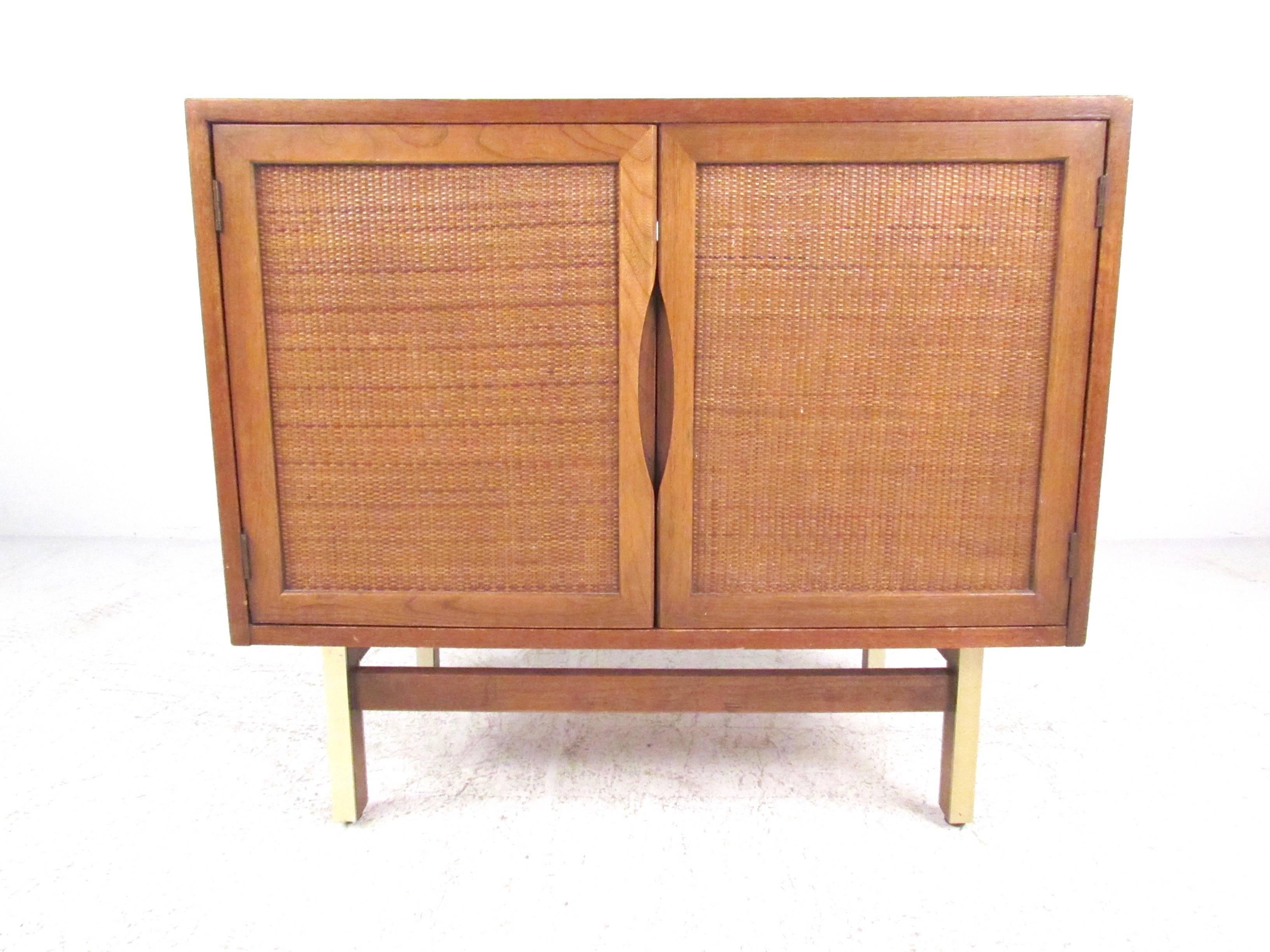 This stylish vintage two-door cabinet makes a unique vintage statement in any setting while offering spacious shelf storage within its divided interior cabinet. Natural wood finish and cane front doors compliment the metal trim on the legs, please