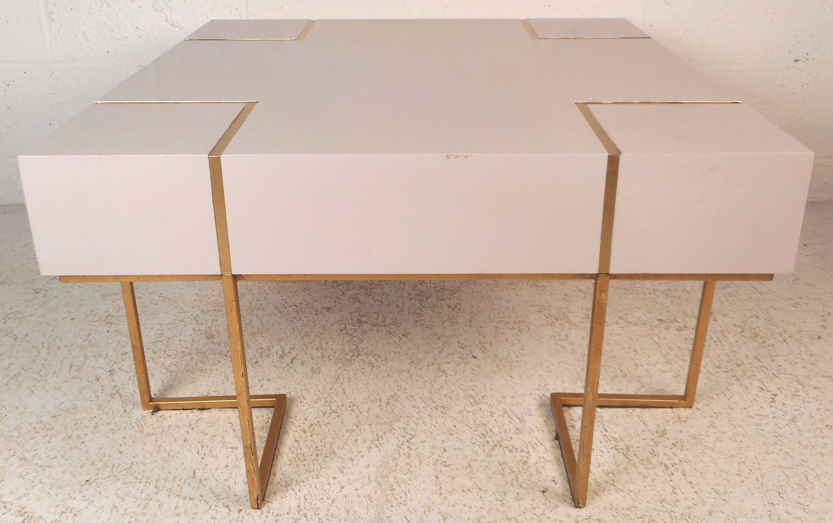 This gorgeous vintage modern decorator coffee table features a unique sculptural gold painted base. The elegant inlay on the top and straight line design add to the mid-century appeal. Quality construction with intricate detail makes this piece the