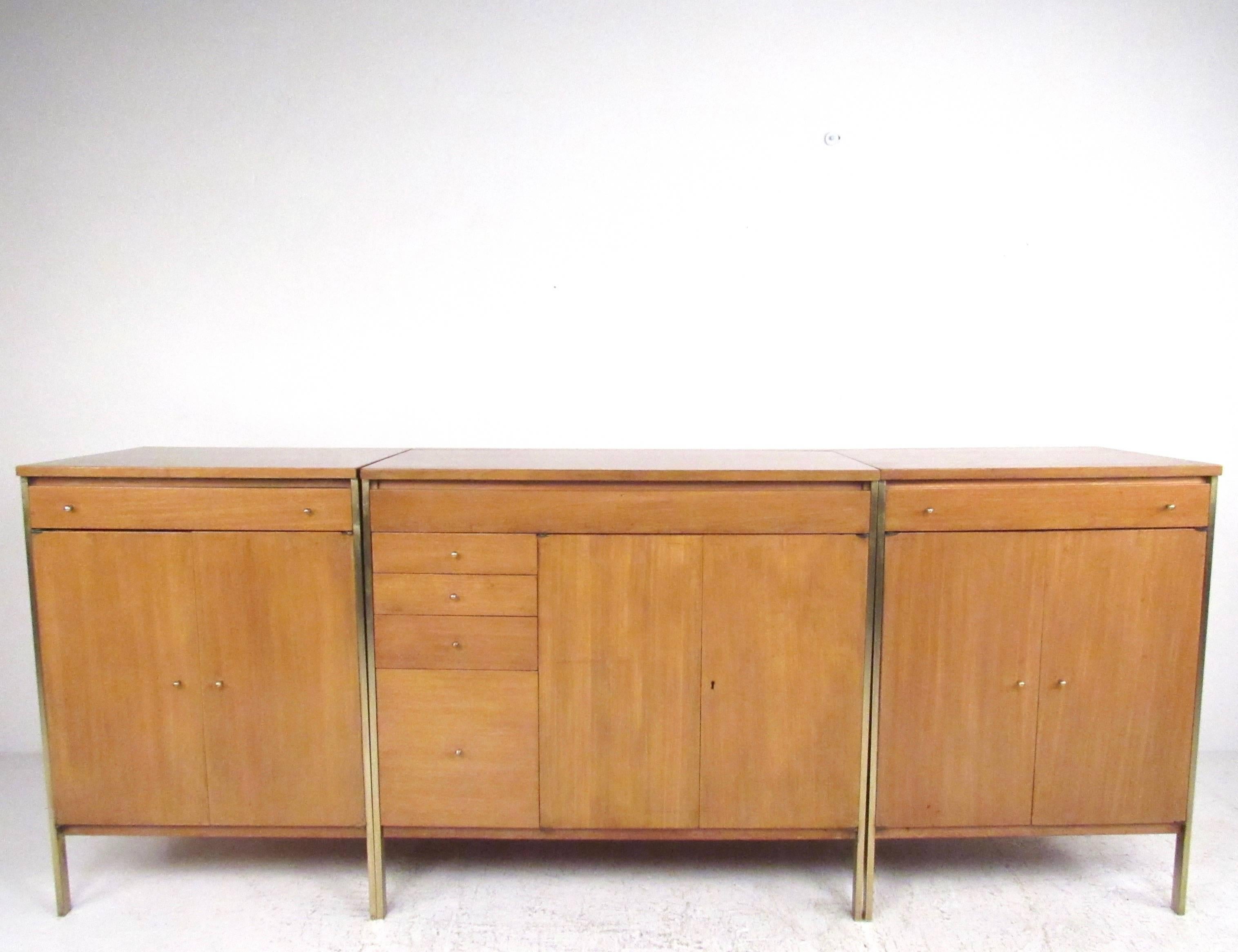 This stylish three-piece sideboard designed by Paul McCobb for H. Sacks and Son as part of the Connoisseur collection is rarely found as a set. Rich natural wood finish, brass trim, and iconic McCobb drawer pulls add to the mid-century style of the