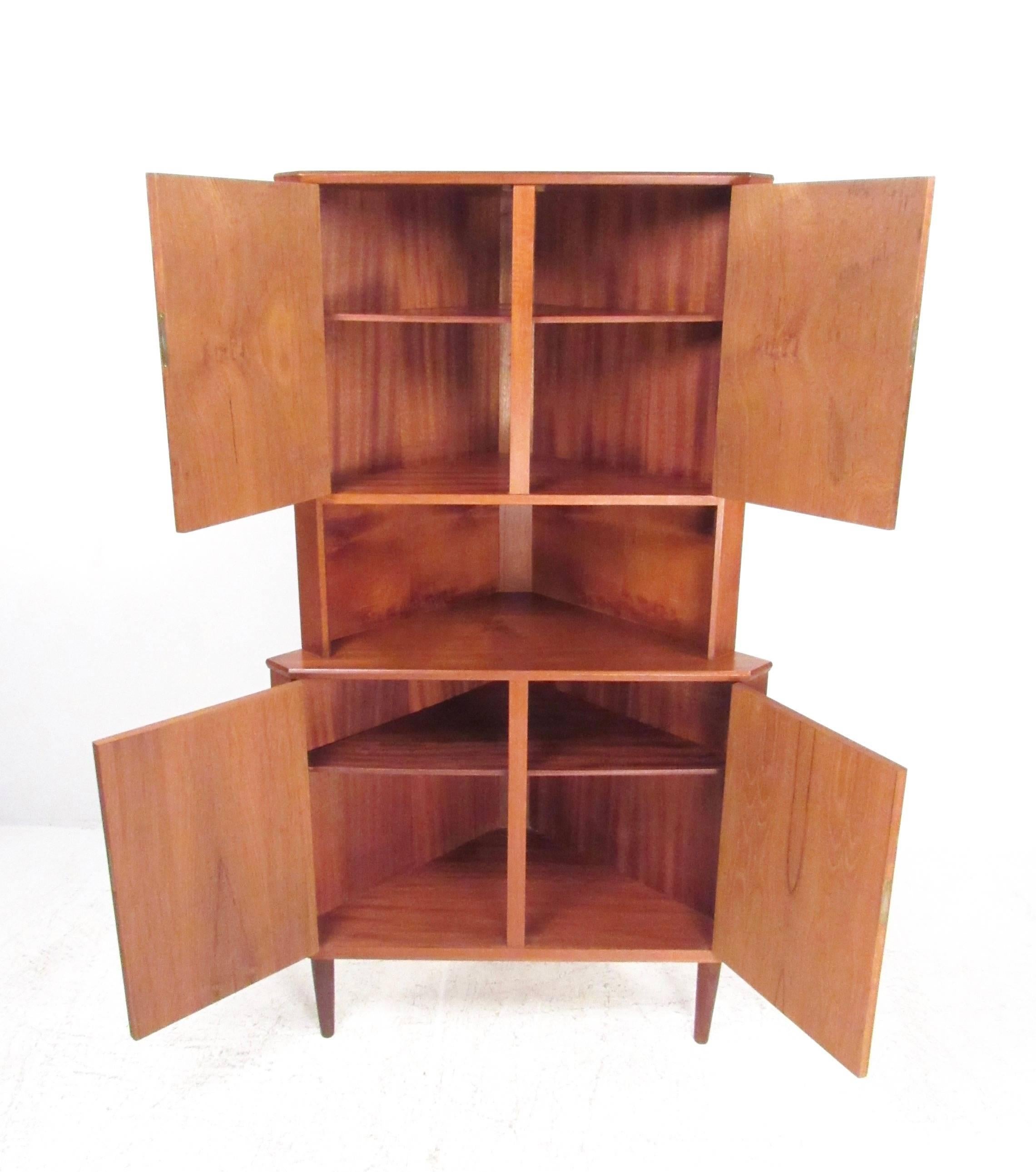 This unique Danish teak corner cabinet features quality Scandinavian Modern construction, dual locking cabinets and open counter storage. Stylish Mid-Century teak storage piece offers spacious interior shelves for storage. Please confirm item