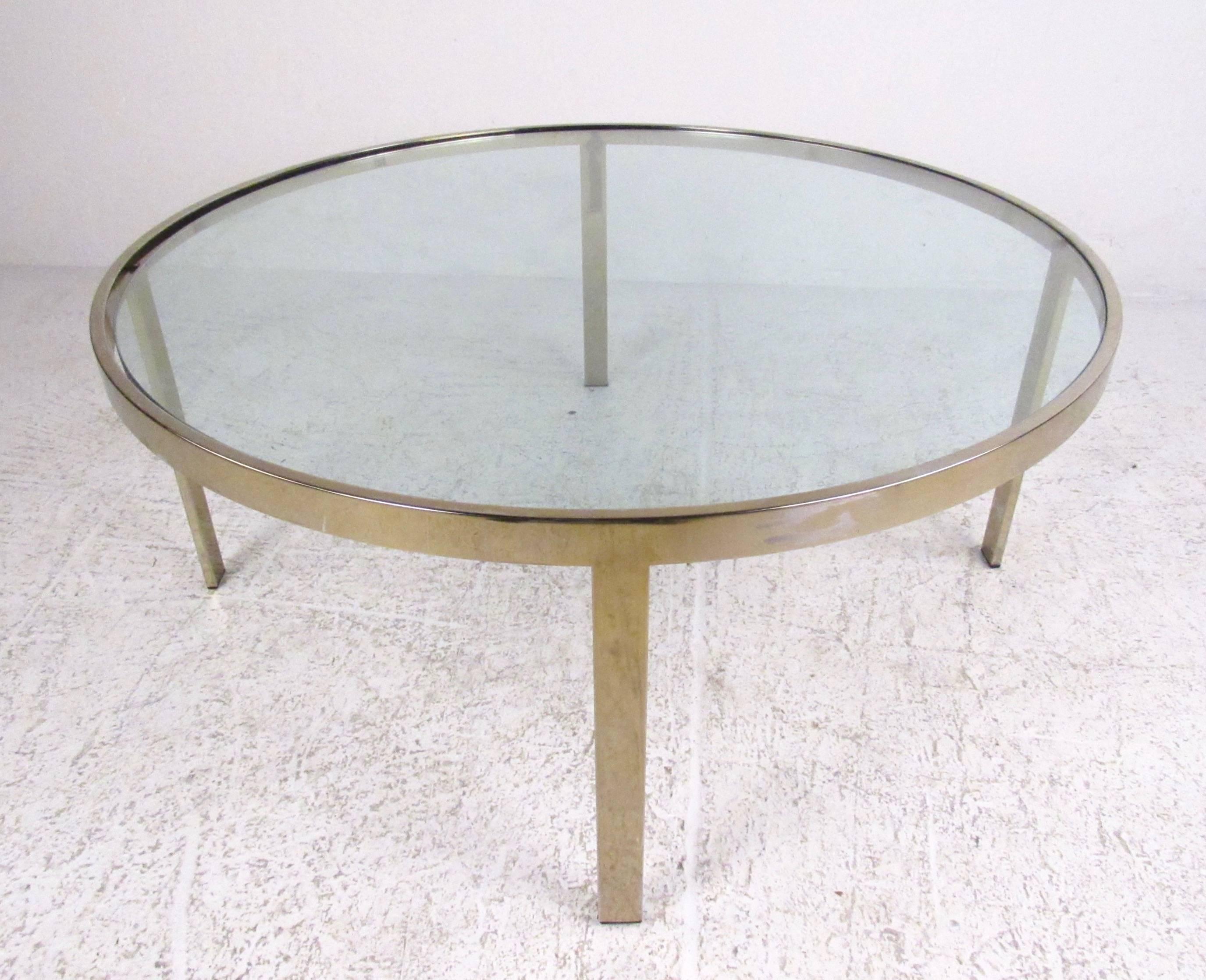 This unique circular coffee table features brass-plated chrome finish with heavy Mid-Century construction, and an inlaid glass top. Elegant modern design makes this a stylish addition to any interior. Please confirm item location (NY or NJ).