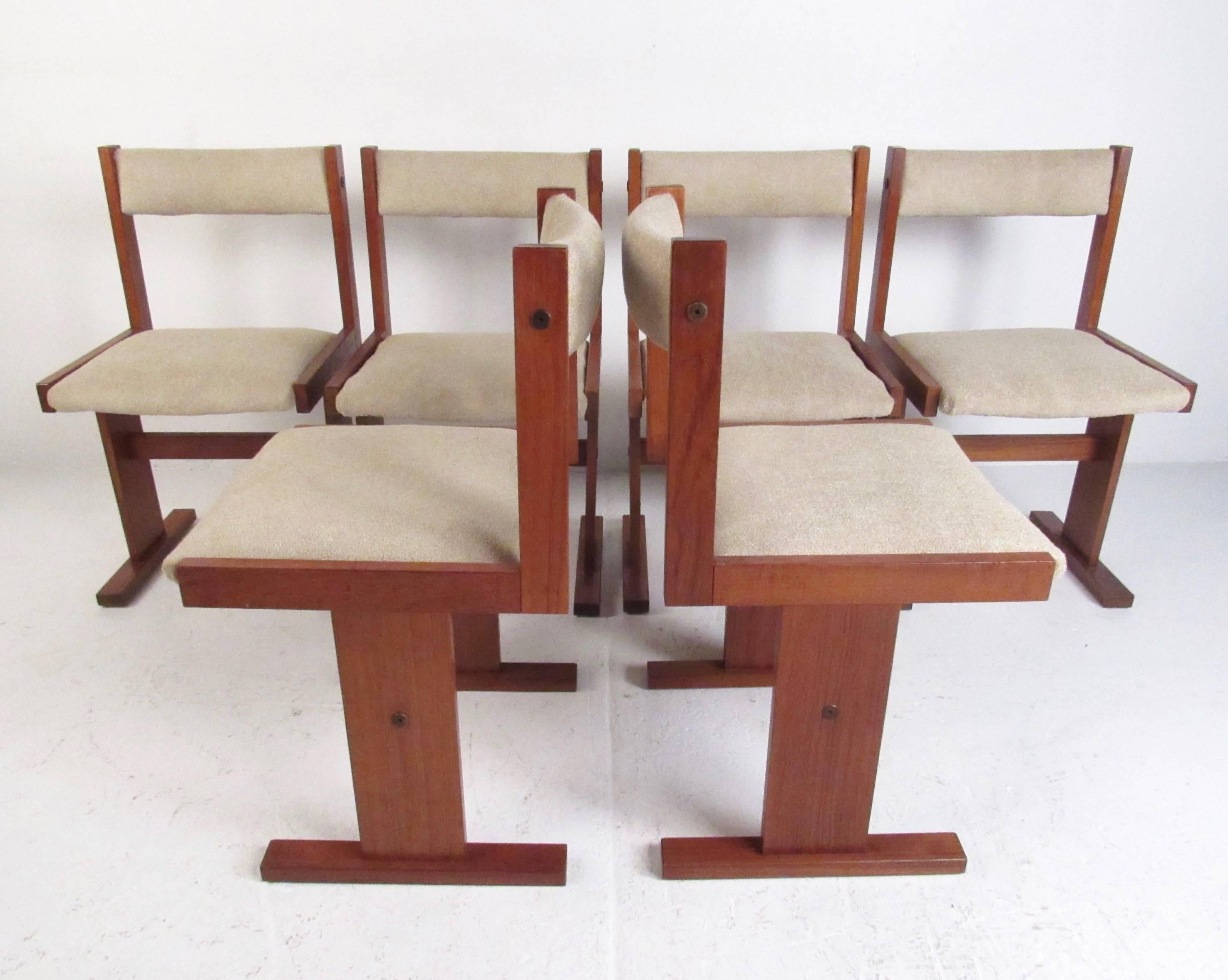 This stylish set of six Danish modern dining chairs feature sturdy teak construction with upholstered seats and seat backs. The unique two leg design and Mid-Century design of the pair make these a beautiful addition to any Scandinavian Modern