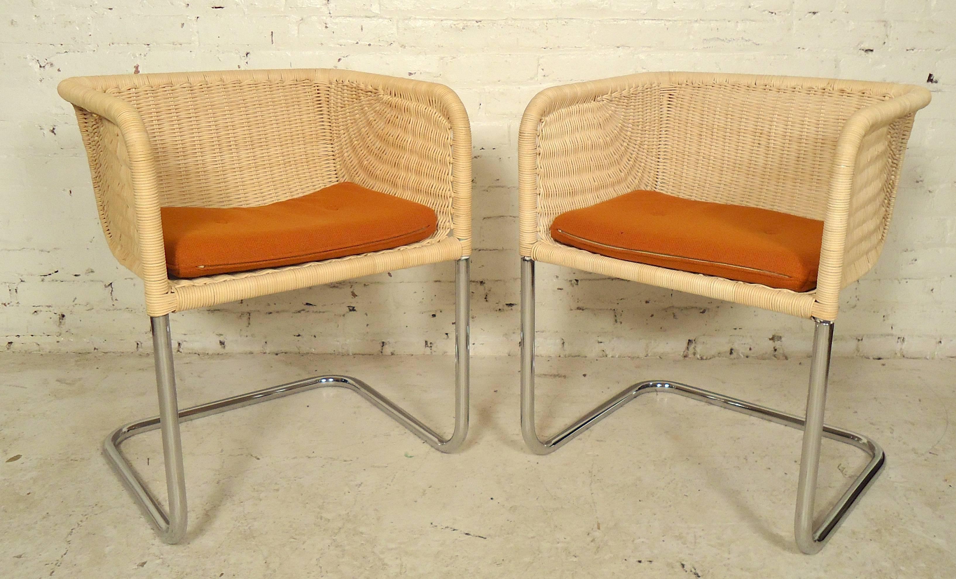 Pair of chrome frame bucket chairs in the style of Harvey Probber, as designed by Preben Fabricius & Jorgen Kastholm in Denmark. These chairs have a seat, back, and arms in woven wicker on a strong polished tubular frame. Soft cushions add to