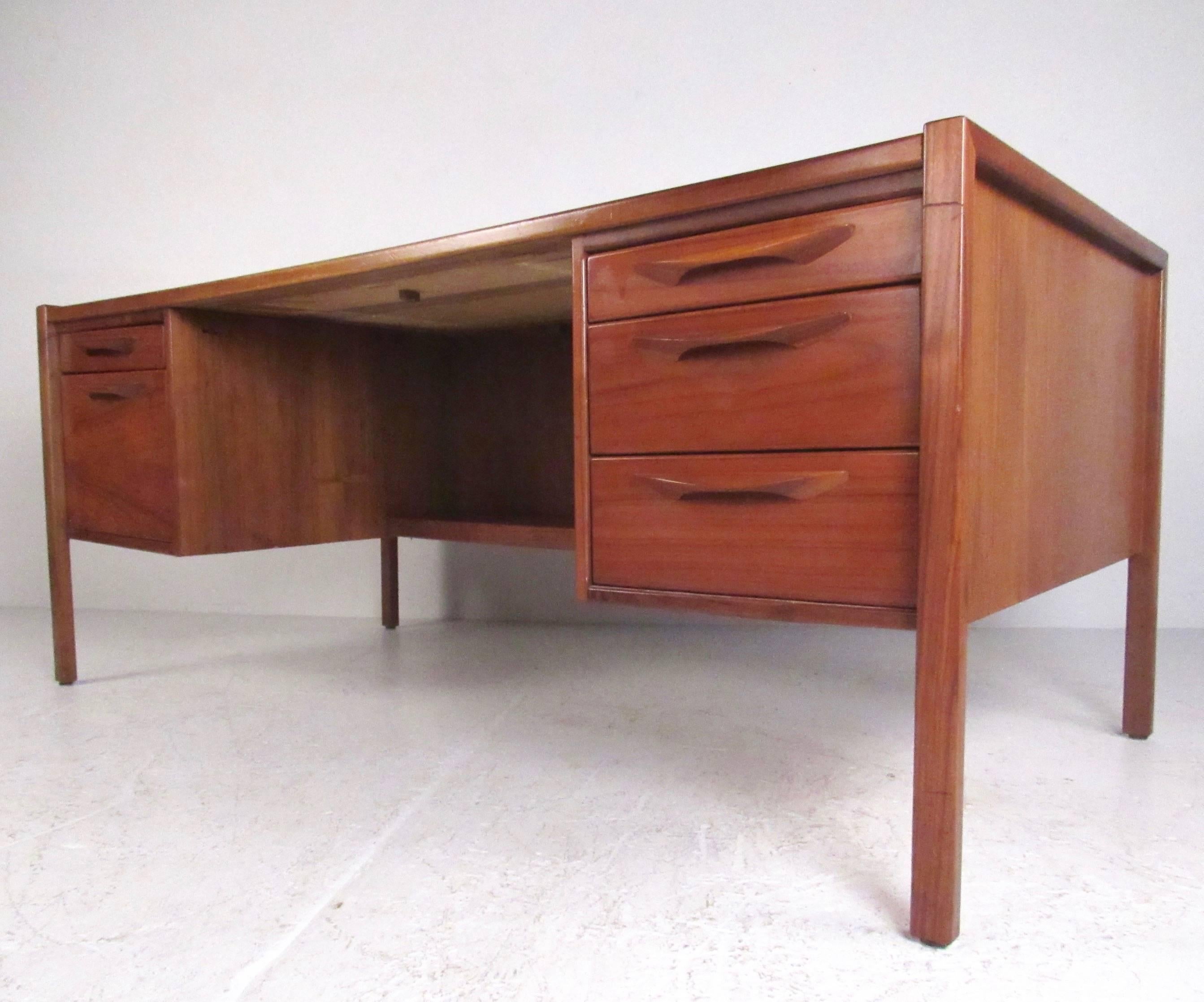 This beautiful Jens Risom executive desk features stylish teak construction with eye lash handles, and plenty of workspace for home or business office. The desks cutaway, finished back adds to it's Mid-Century charm, making an impressive visual