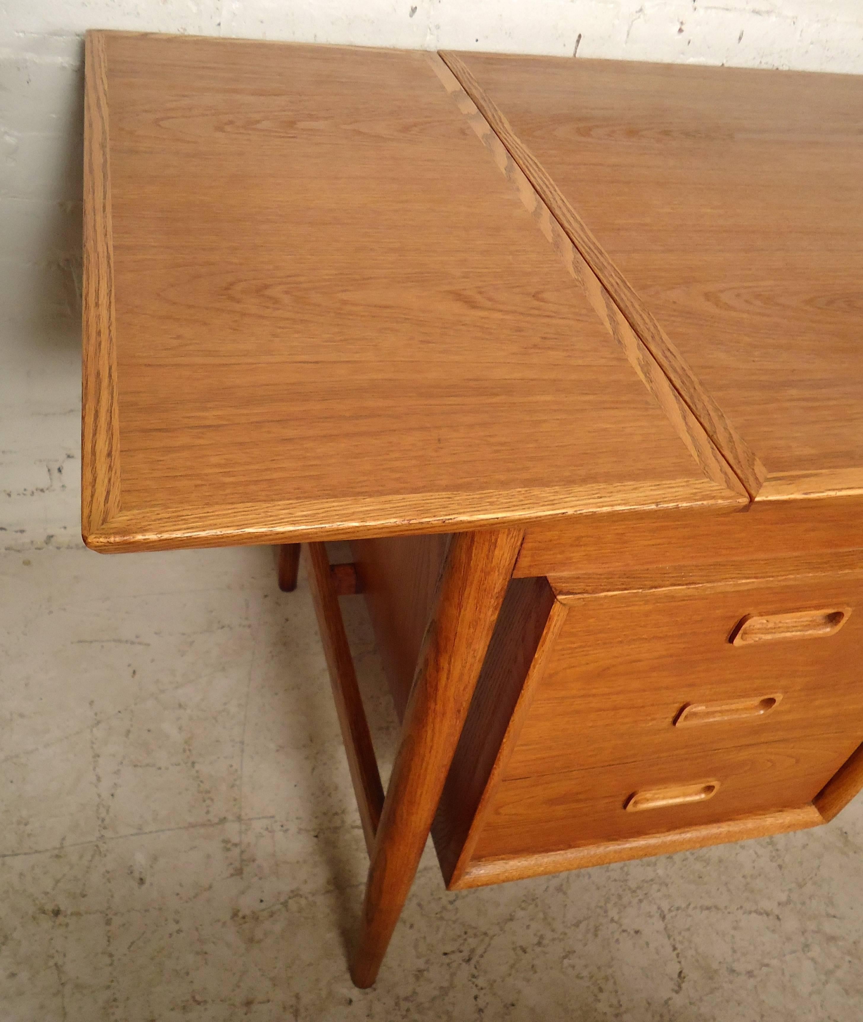 This gorgeous drop-leaf desk is very unique, features rich walnut grain, a set of four drawers, one smaller drawer on top and one large drawer at the bottom. Also features a sliding top that adjusts to extend the top.

 Please confirm item