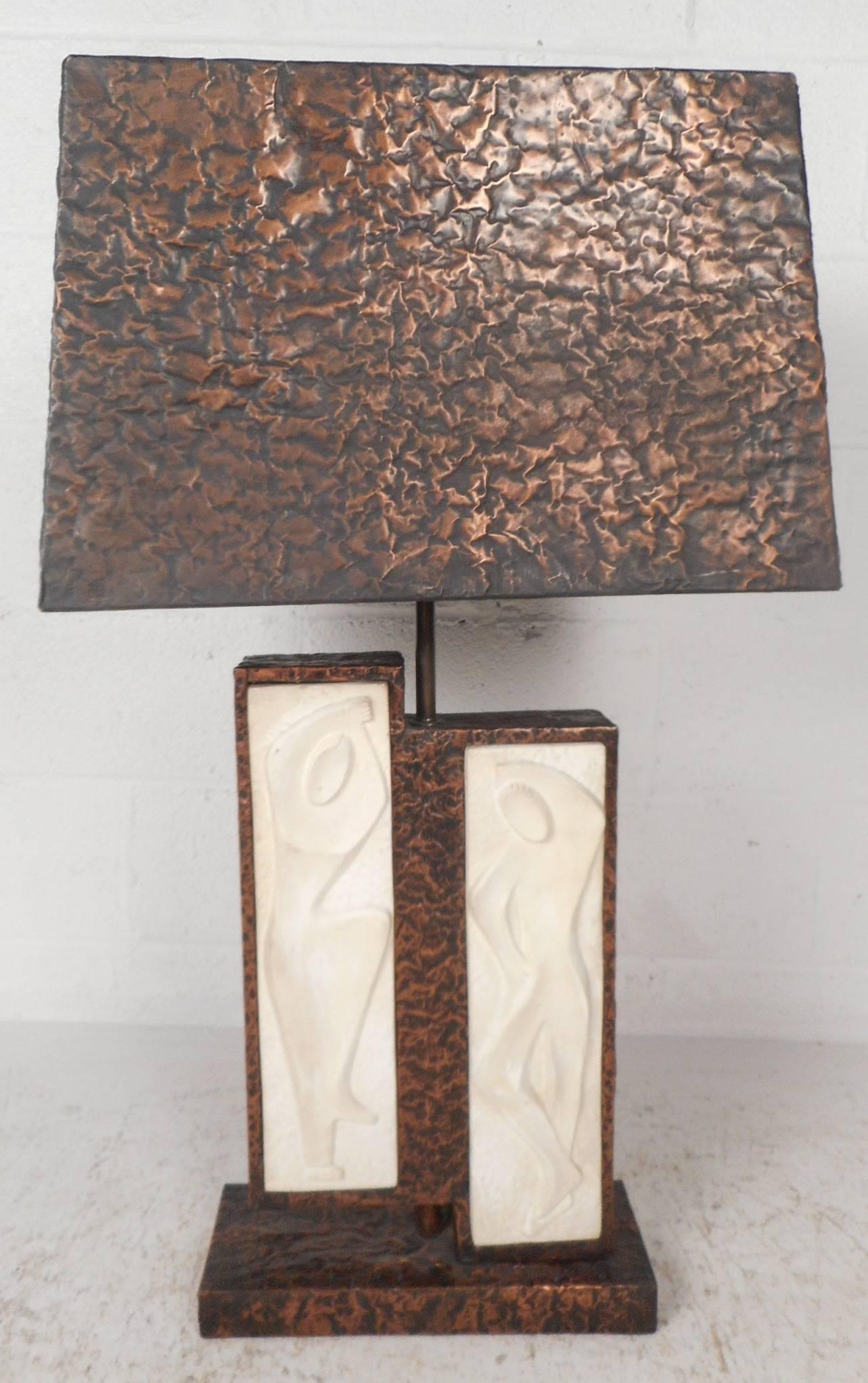 This stunning vintage modern table lamp features stylish designs on the front with a copper frame and shade. Sleek design has two spots for bulbs ensuring maximum lighting in any setting. Please confirm item location (NY or NJ). 

Measures: Lamp