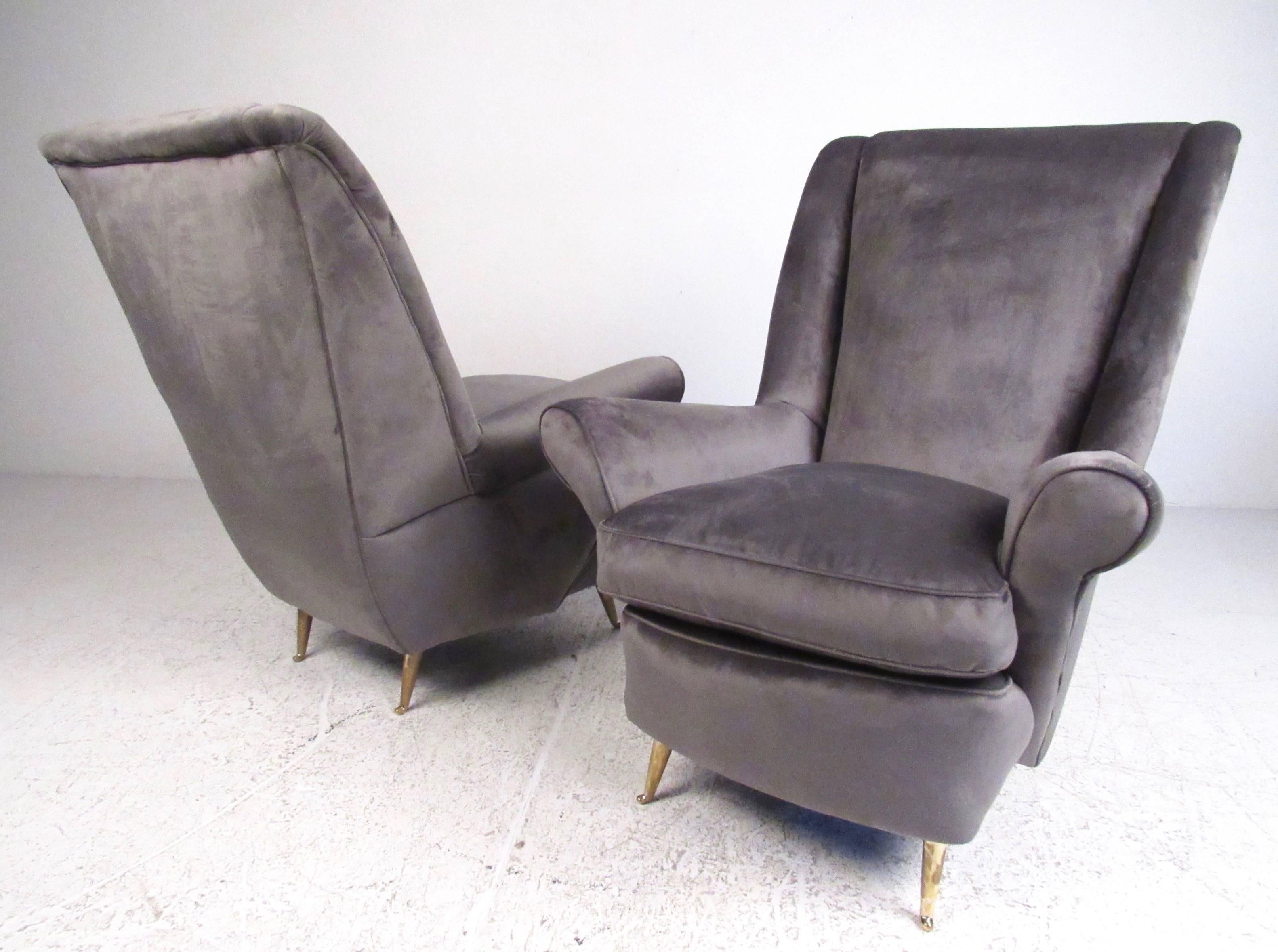 This vintage pair of Arredamenti ISA armchairs feature dramatic sculptural frames, tapered brass legs, and plush suede-like upholstery. This exquisite pair of Italian modern lounge chairs combine comfort and style to make a striking statement in any