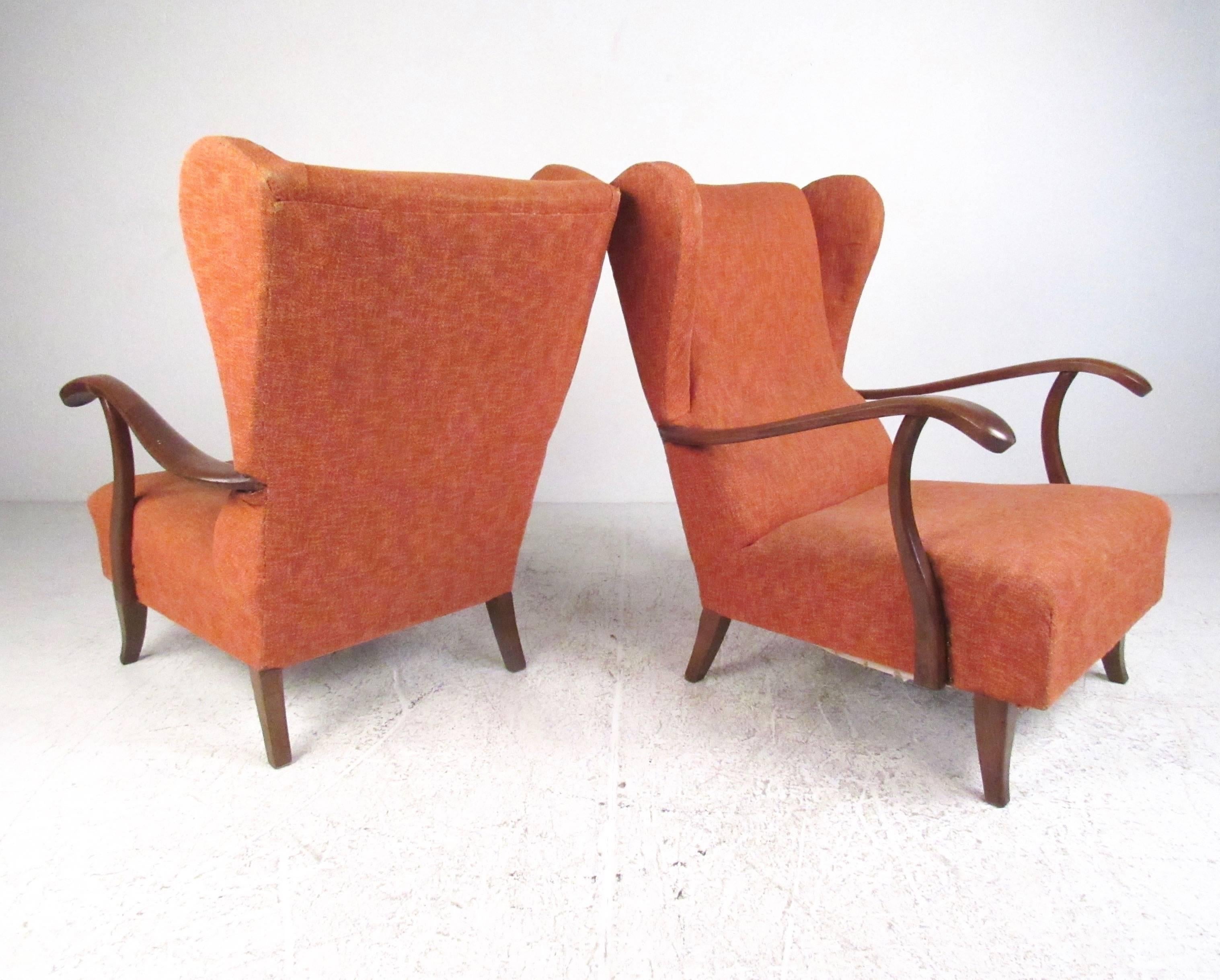 This stylish pair of high back Paolo Buffa attributed armchairs feature sculpted wingback design and elegant hardwood arms. Tapered legs and unique vintage fabric add to the Mid-Century Modern charm of these Italian lounge chairs. Please confirm