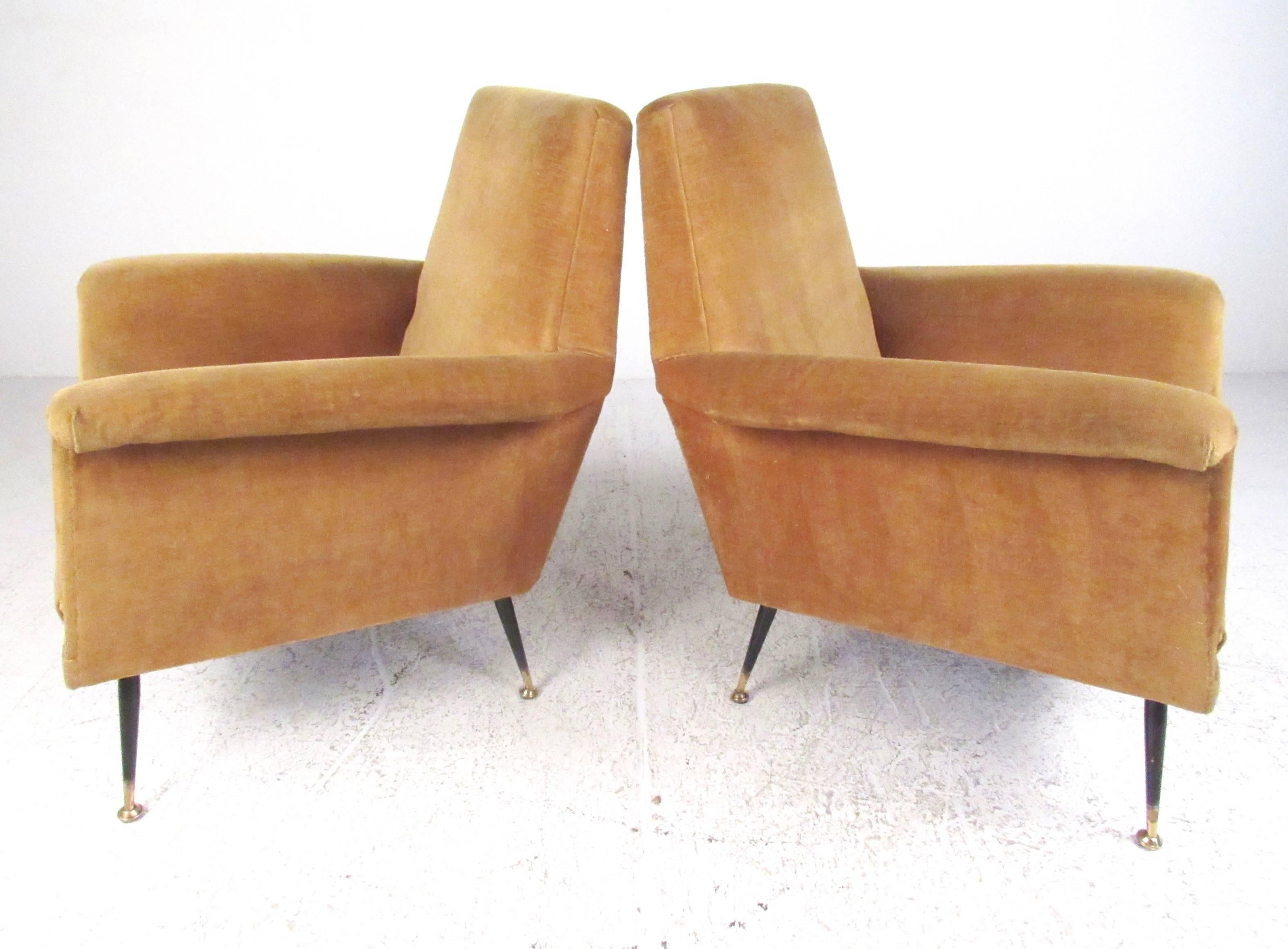 This beautiful sculpted pair of 1950s Italian modern armchairs feature tapered legs with brass tipped feet. Unique arm rests and comfortably padded seating makes this vintage pair of Marco Zanuso style club chairs an impressive mid-century addition