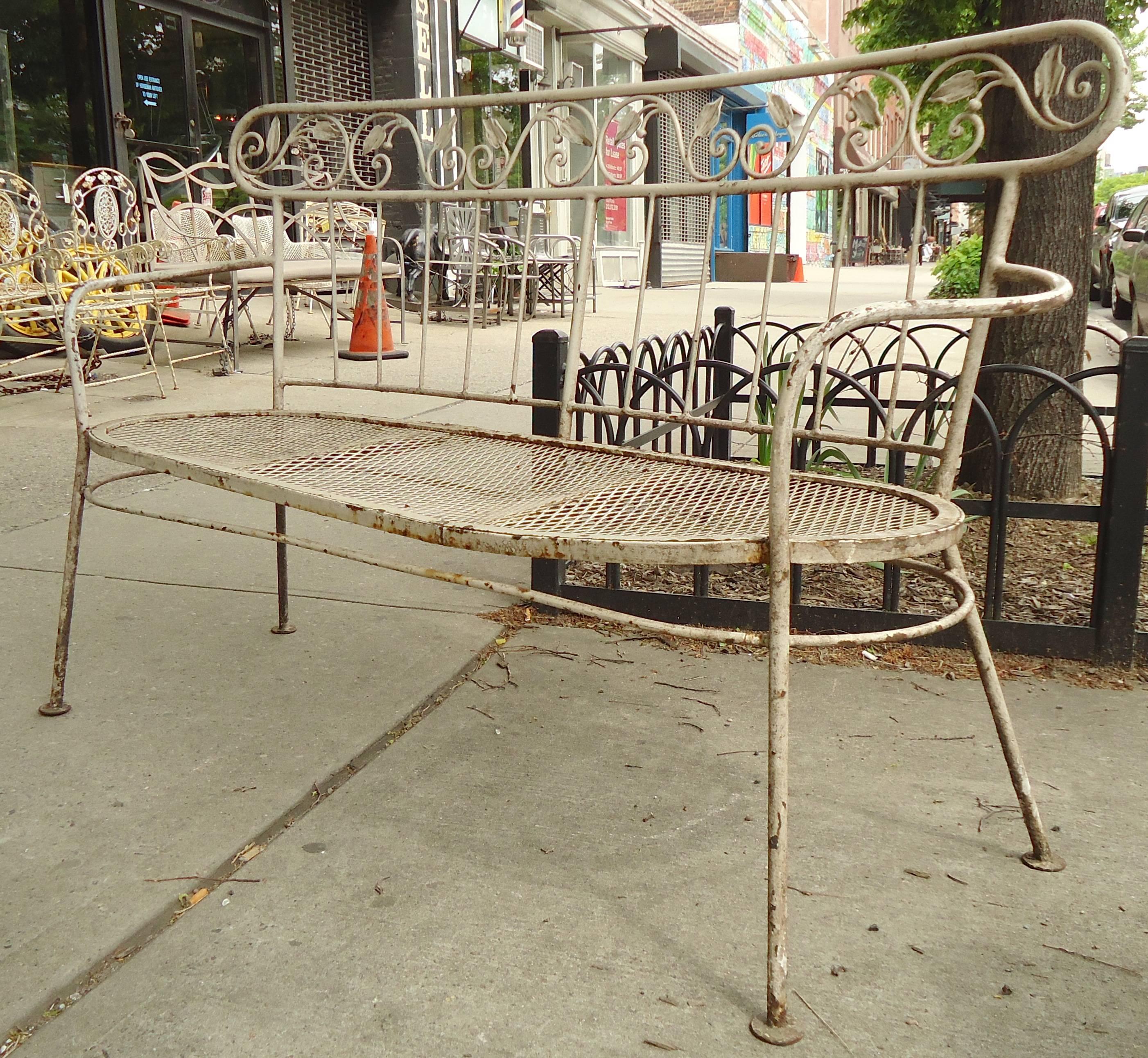 Pair of outdoor benches in iron. Each love seat has a strong frame with curving arms, slat backs and decorative leaf trim.

(Please confirm item location, NY or NJ, with dealer).
 