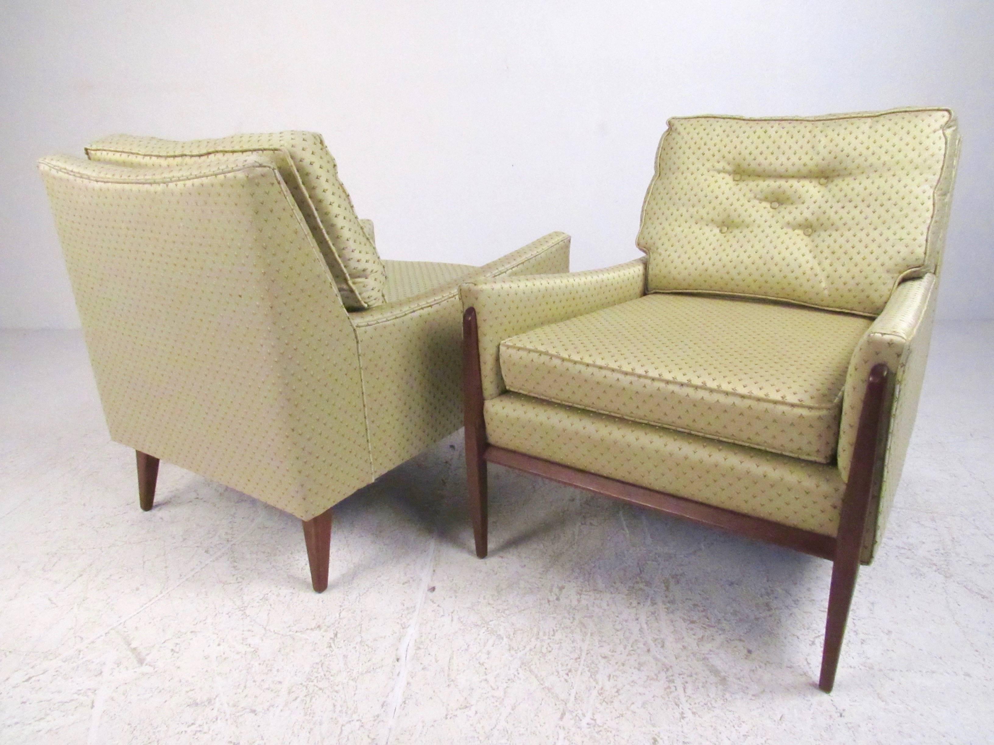 This exquisite pair of Paul McCobb style lounge chairs feature comfortably upholstered seats with tufted fabric and sculpted walnut frames. This stylish Mid-Century Modern pair of chairs make a beautiful addition to home or business seating. Please