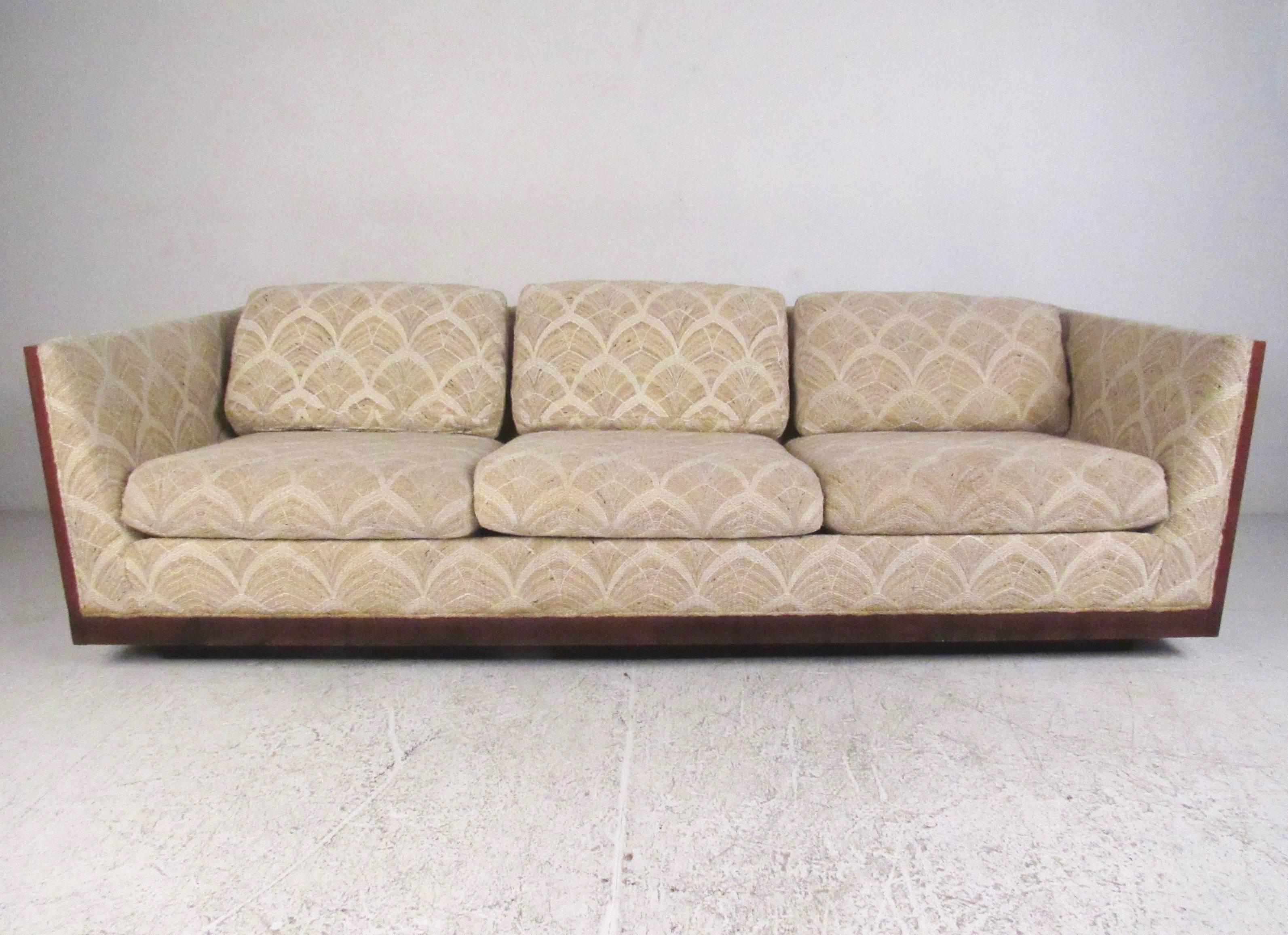 This stylish three-seat sofa features heavy teak frame and sturdy pedestal style base. Mid-Century Modern design in the style of Milo Baughman for Forecast Furniture, this large and impressive sofa makes a substantial addition to any seating area.