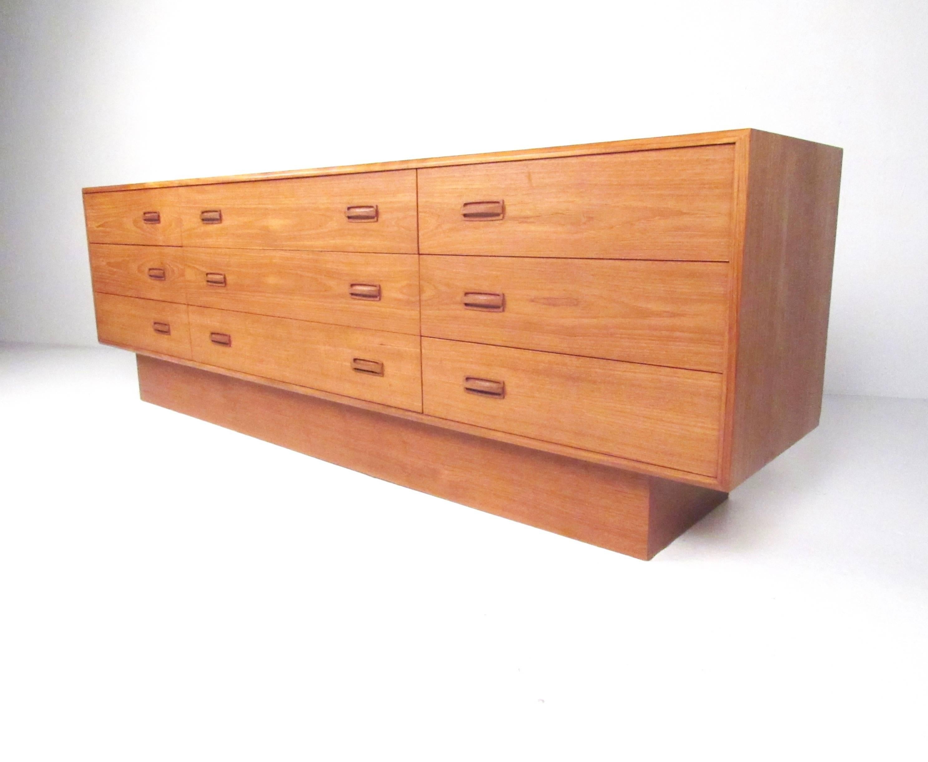 This stylish bedroom dresser features nine spacious drawers with matched teak veneer finish and well crafted carved pulls. The unique Scandinavian modern style of this Canadian piece makes this an impressive storage piece in any setting. Please