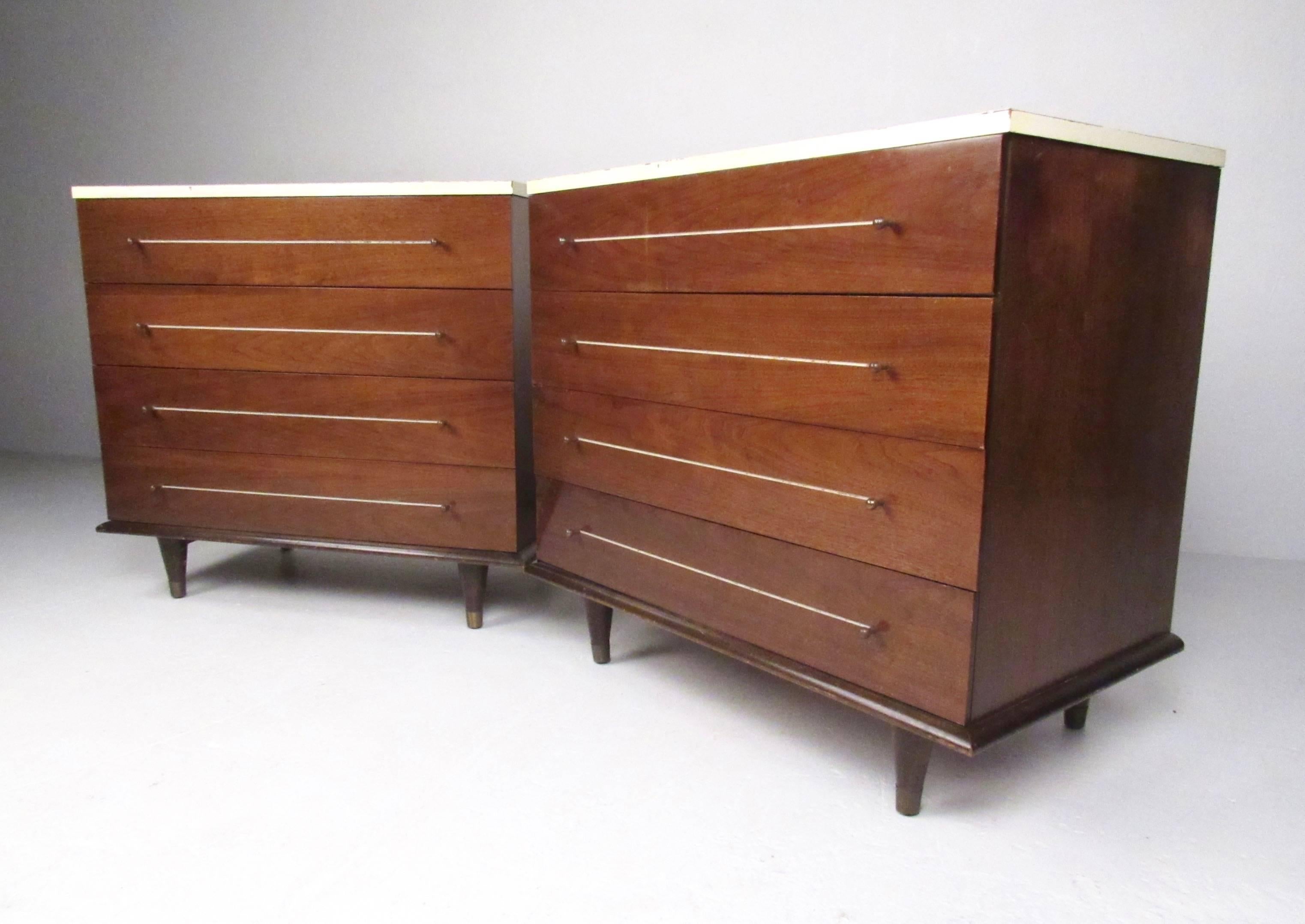 This pair of American modern dressers each feature four wide drawers for ample bedroom storage. Unique white tops, circular drawer pulls and tapered brass sabot legs add to the Mid-Century style of this pair of Link Taylor bachelor chests. Please