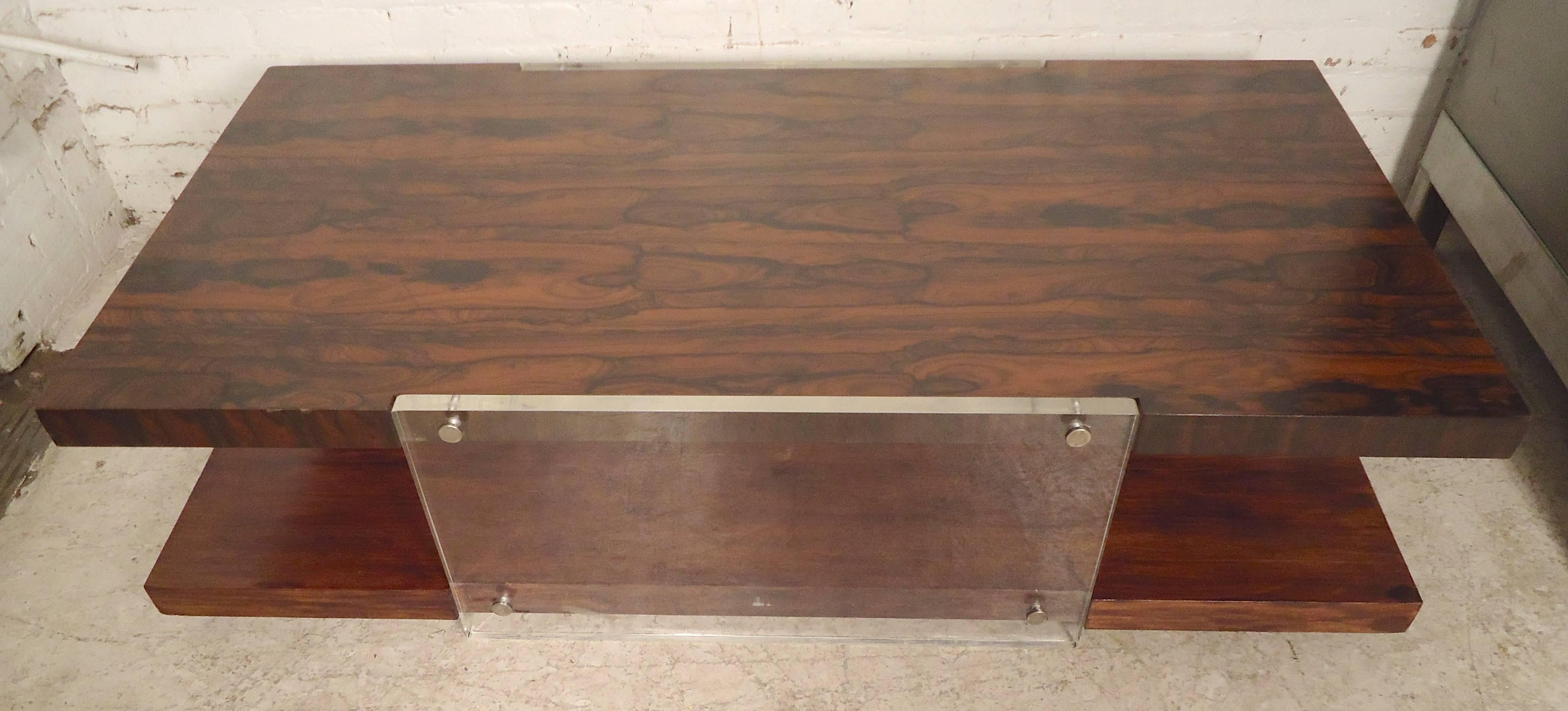 Stunning and substantial vintage modernist two-tiered coffee table. The rosewood veneer features a truly one-of-a-kind swirling grain pattern.  Lucite slabs lend late 20th-century influence without detracting from the natural beauty of wood.  Robust