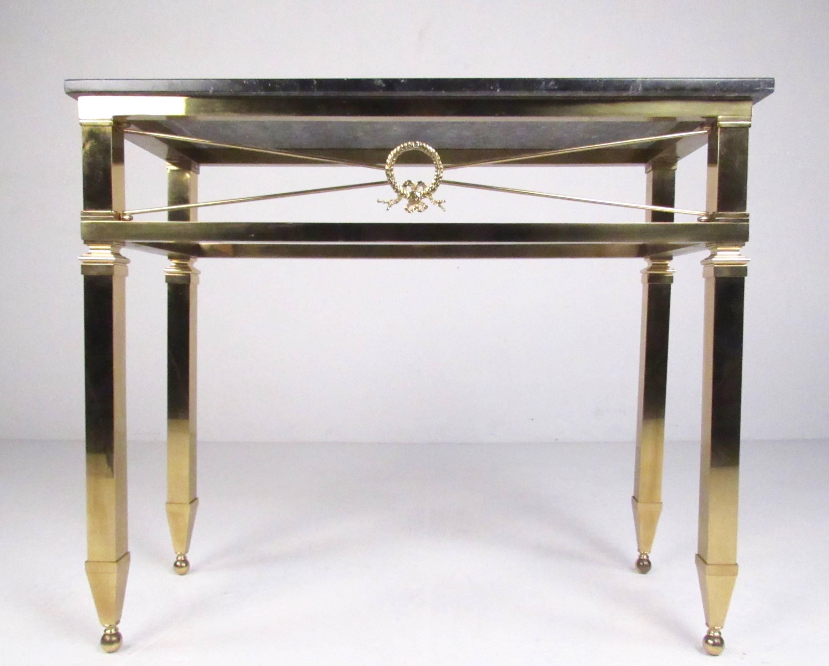 This elegant Italian Directoire style console table features ornate brass frame with heavy marble top. This impressive hall table boasts sleek tapered legs, perfect console height, and impressive medallion detail, making a striking addition in any