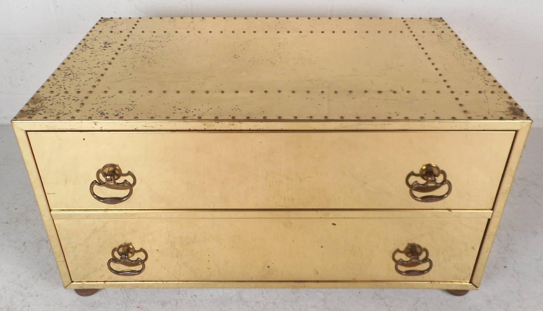 This stunning vintage modern chest has two hefty drawers with unique sculpted pulls. This versatile Mid-Century piece can be used as a nightstand, end table, or simply a decorative chest. Elegant design made of brass with studded detail throughout