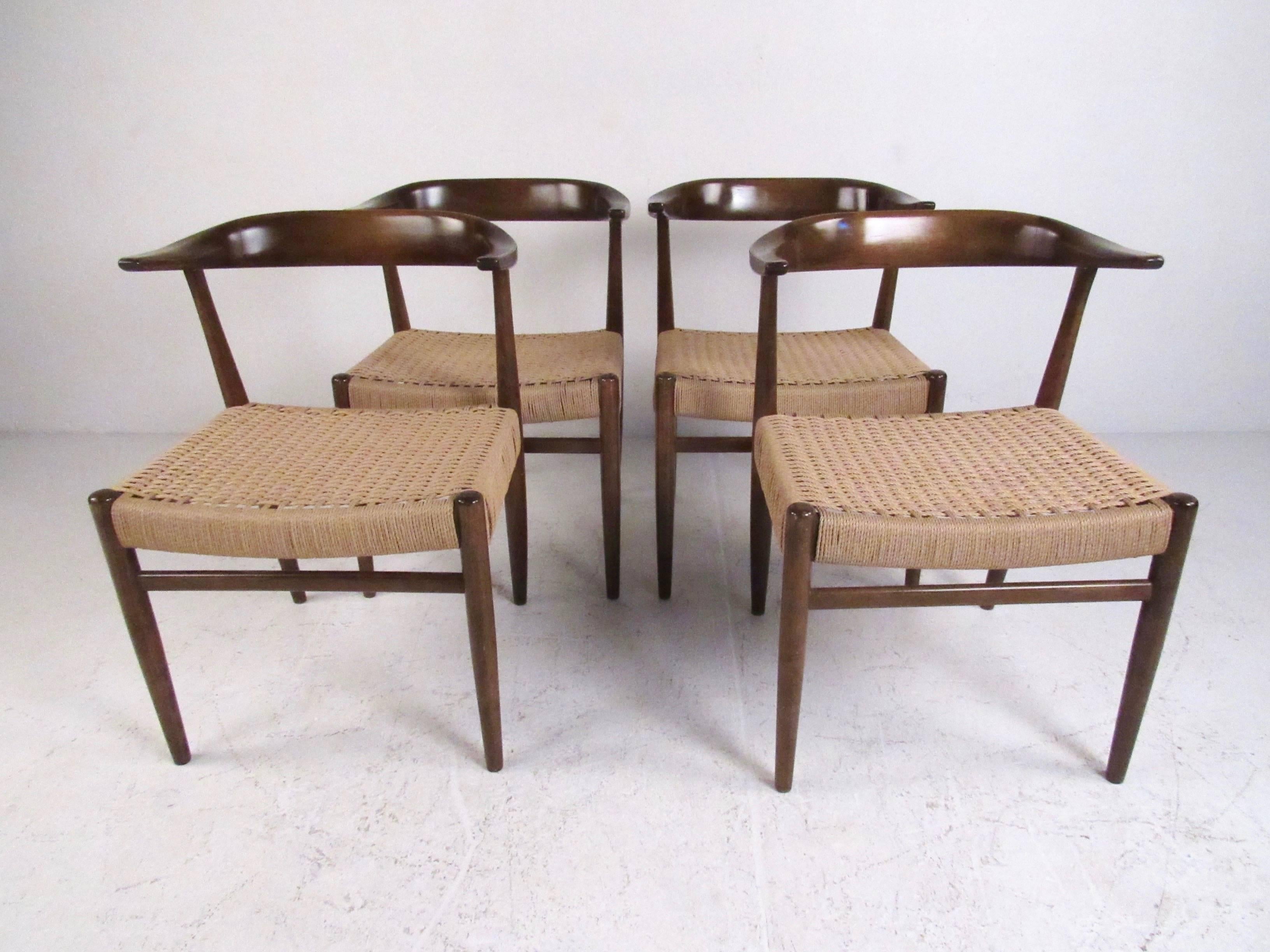This stylish set of four Scandinavian style dining chairs feature sturdy Mid-Century construction, paper cord seats, and rounded Horn style seat backs. These unique chairs feature Hans Wegner style design including sculpted seat back and tapered