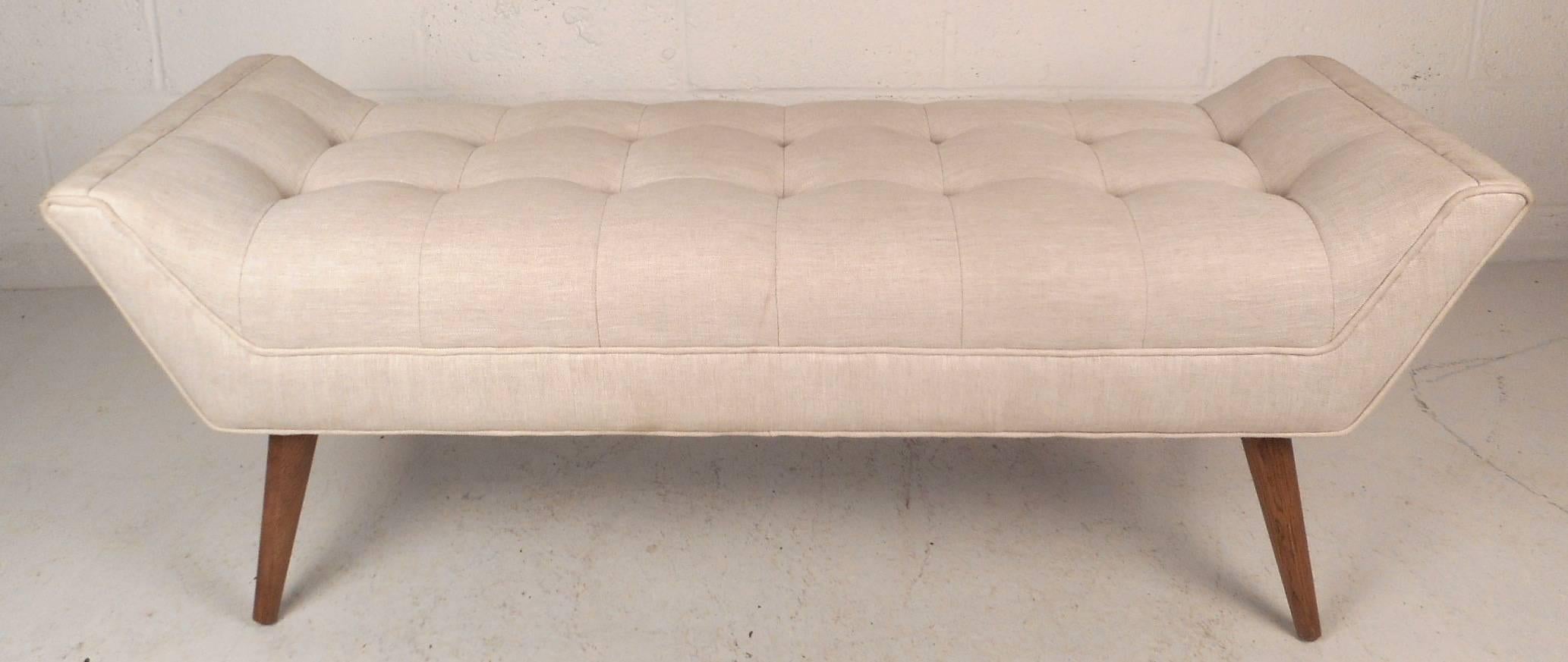 Stunning Mid-Century Modern style window bench in the style of Paul McCobb features unique tapered and splayed legs. Stylish design with plush white tufted upholstery and thick padded seating. This versatile seat can function as an ottoman or a