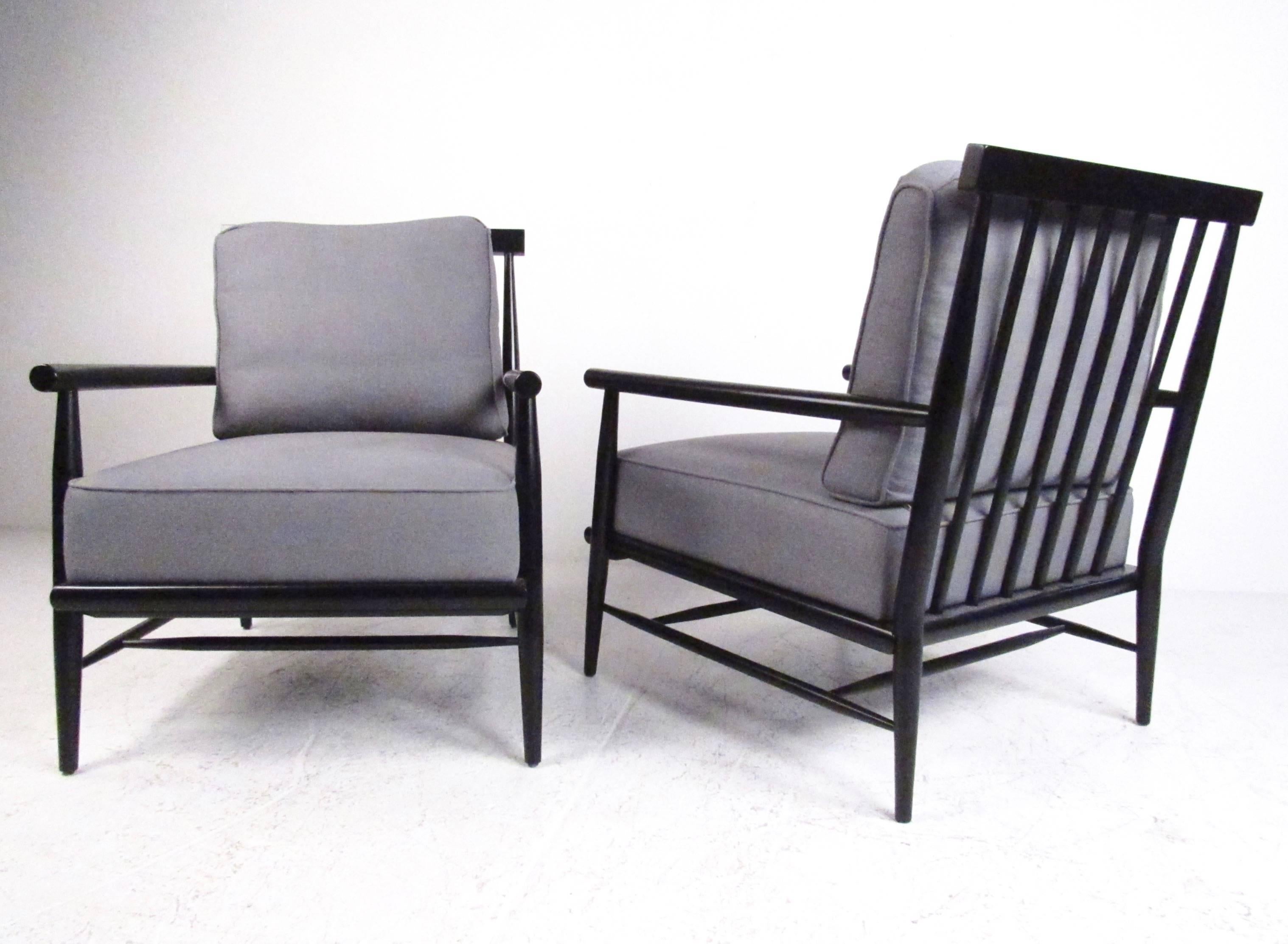 This exquisite pair of modern lounge chairs feature sculpted ebonized frames in a unique Paul McCobb style. Spoked seat backs set with tapered frames provide a wide base for these comfortable and stylish armchairs. Impressive vintage modern addition