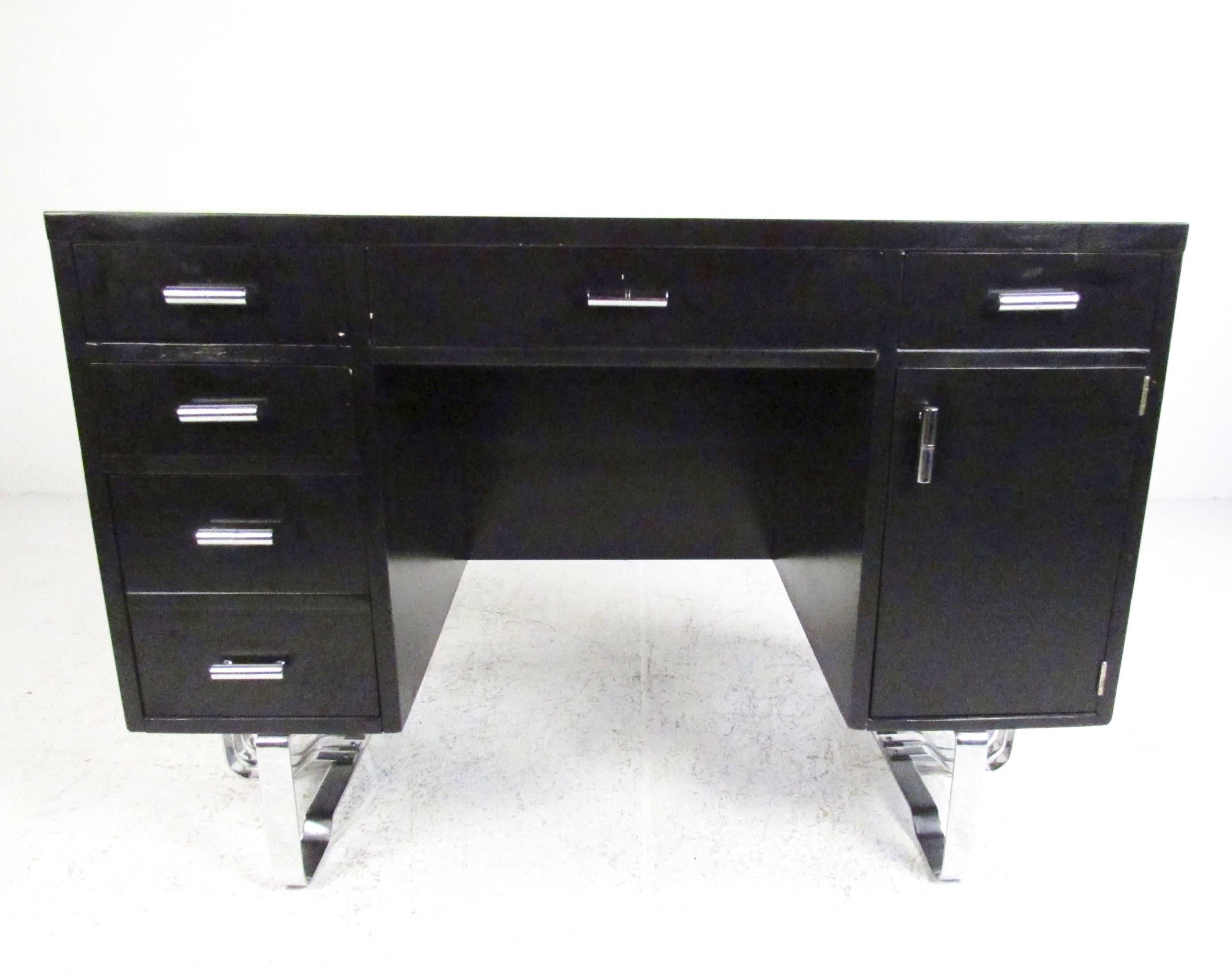 This stylish black lacquer writing desk features the unique vintage design of Mid-Century Modern designer Wolfgang Hoffman. Spacious drawers with tubular chrome handles, sculptural metal base, and clean modern lines make this an eye-catching