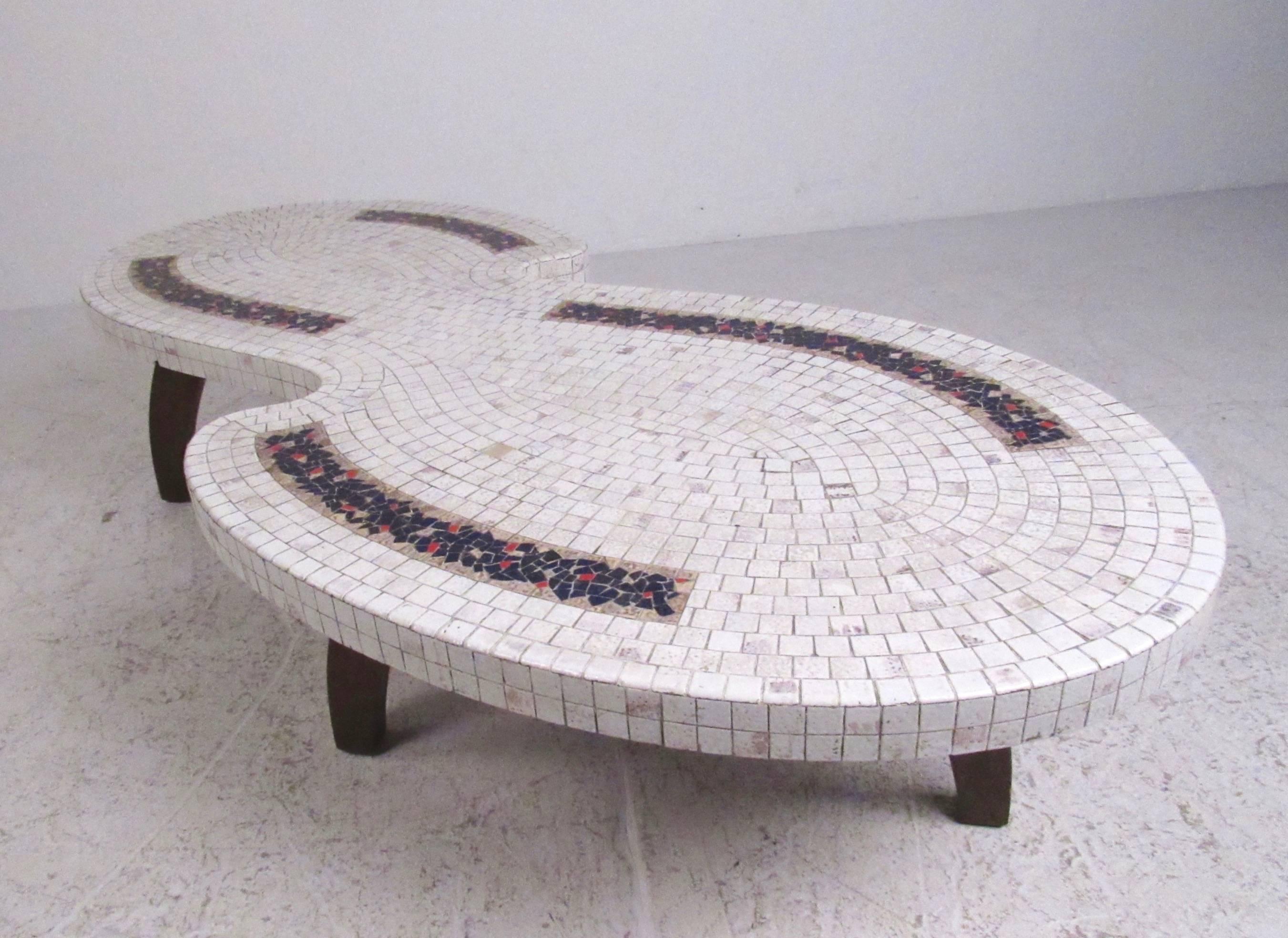 The Mid-Century Modern style of this vintage tile table features unique hardwood legs, decorative mosaic tile top, and stylish sculpted tabletop. Striking and visually impressive table makes an eye-catching addition to any seating area. Please