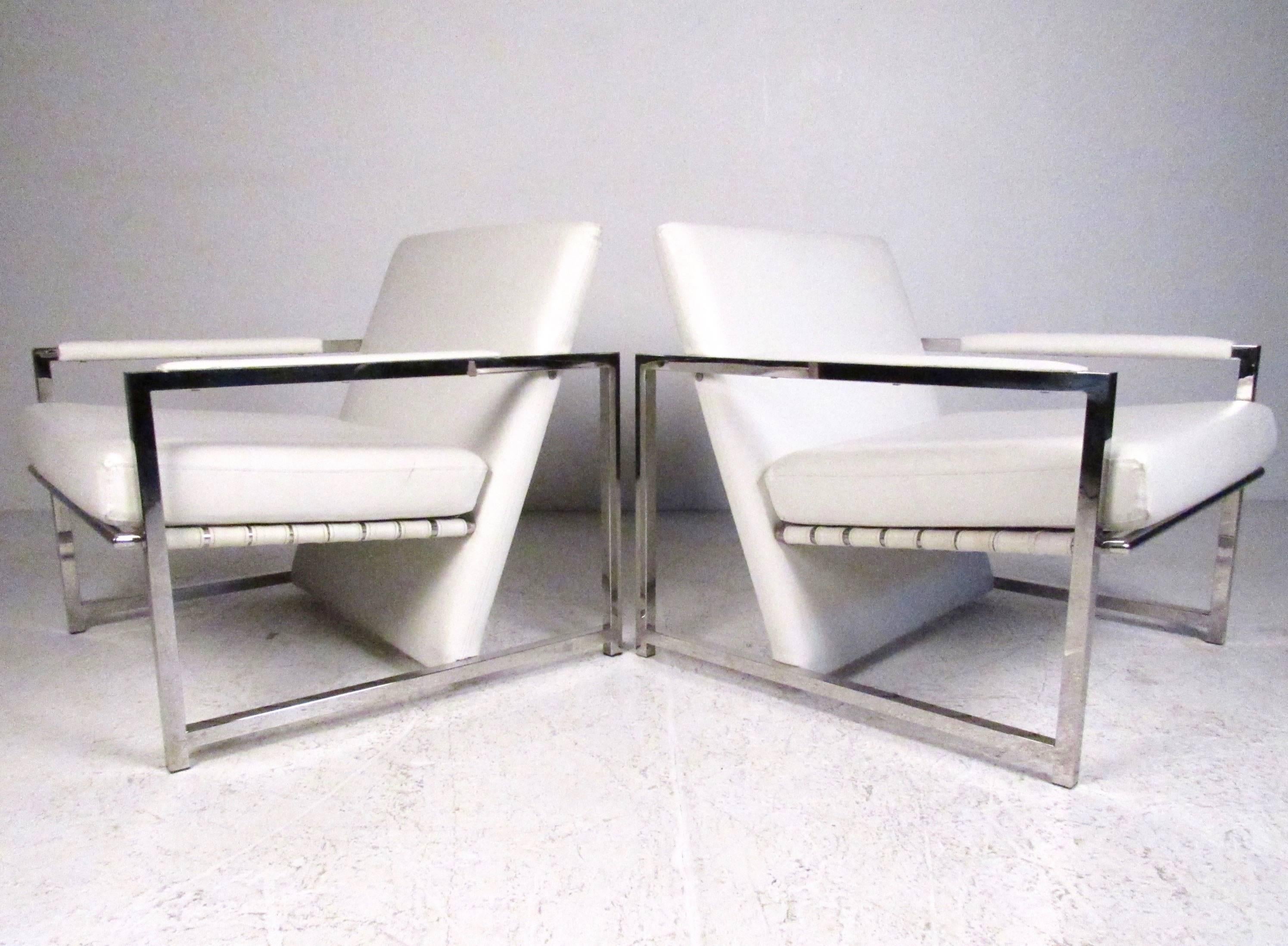 This unique pair of chrome and vinyl club chairs feature unique Mid-Century Modern style and comfortable proportions. Stylish angled seat backs, comfortable upholstery, and padded heavy chrome frames add to the modern appeal of these lounge chairs.