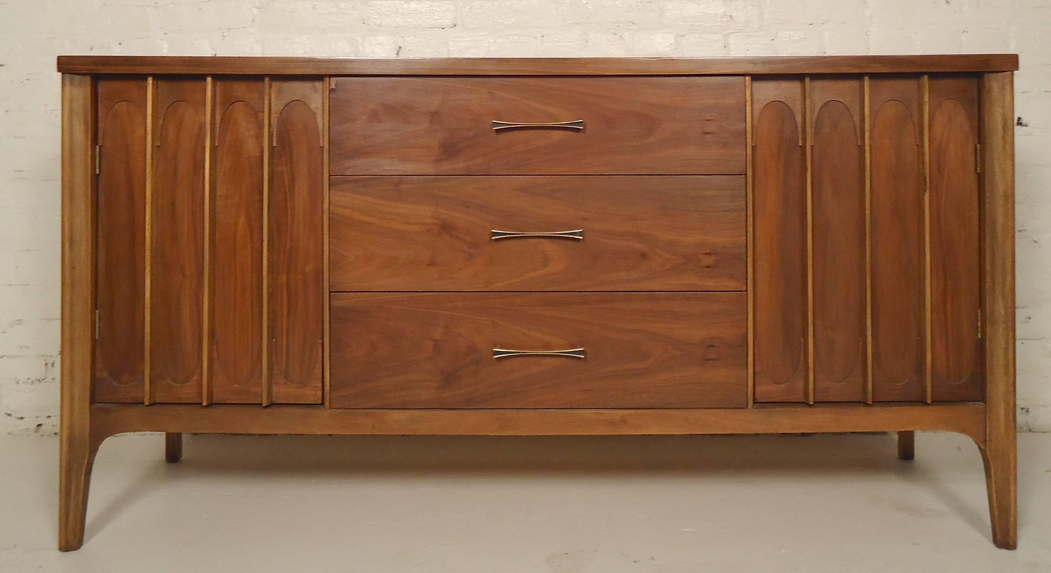 Vintage modern long dresser with wide drawers and side cabinets. Walnut grain, sculpted doors, brass colored handles. Great for bedroom or living room.

(Please confirm item location - NY or NJ - with dealer).
 