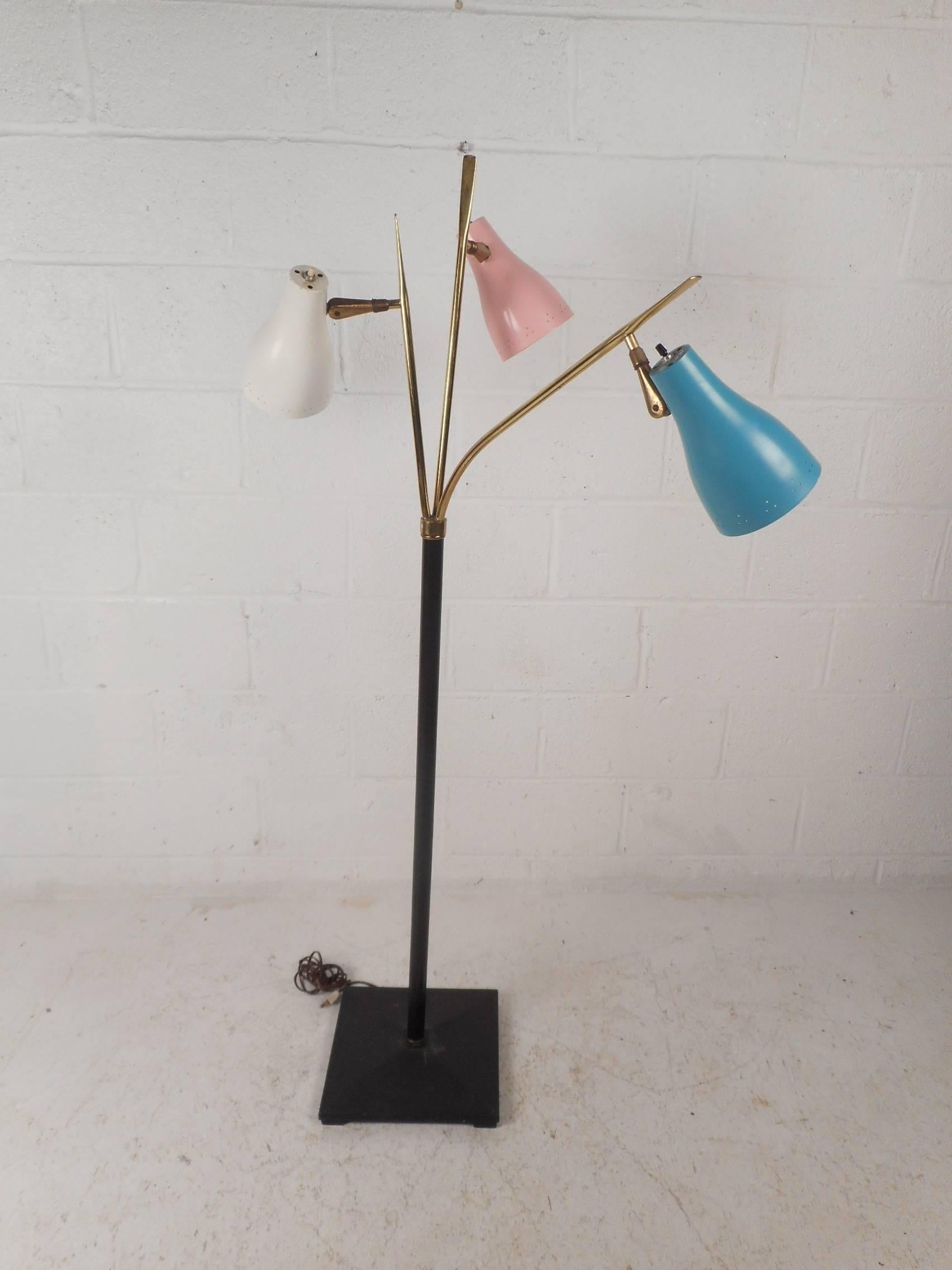 This beautiful vintage modern floor lamp features three various colored adjustable lamp heads. Sleek design has the ability to swivel without moving the base with the three pronged brass top. This elegant Mid-Century piece is sure to add style and