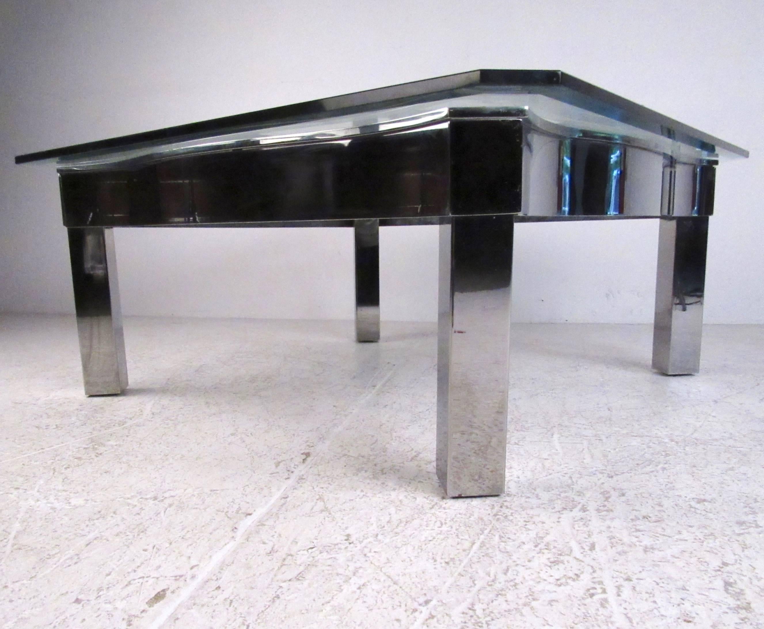 This large coffee table features a shapely chrome frame, heavy glass top with beveled edge, and makes an impressive addition to any seating area. The table's unique shape and large size is given added support by X-frame bracer between the four legs.