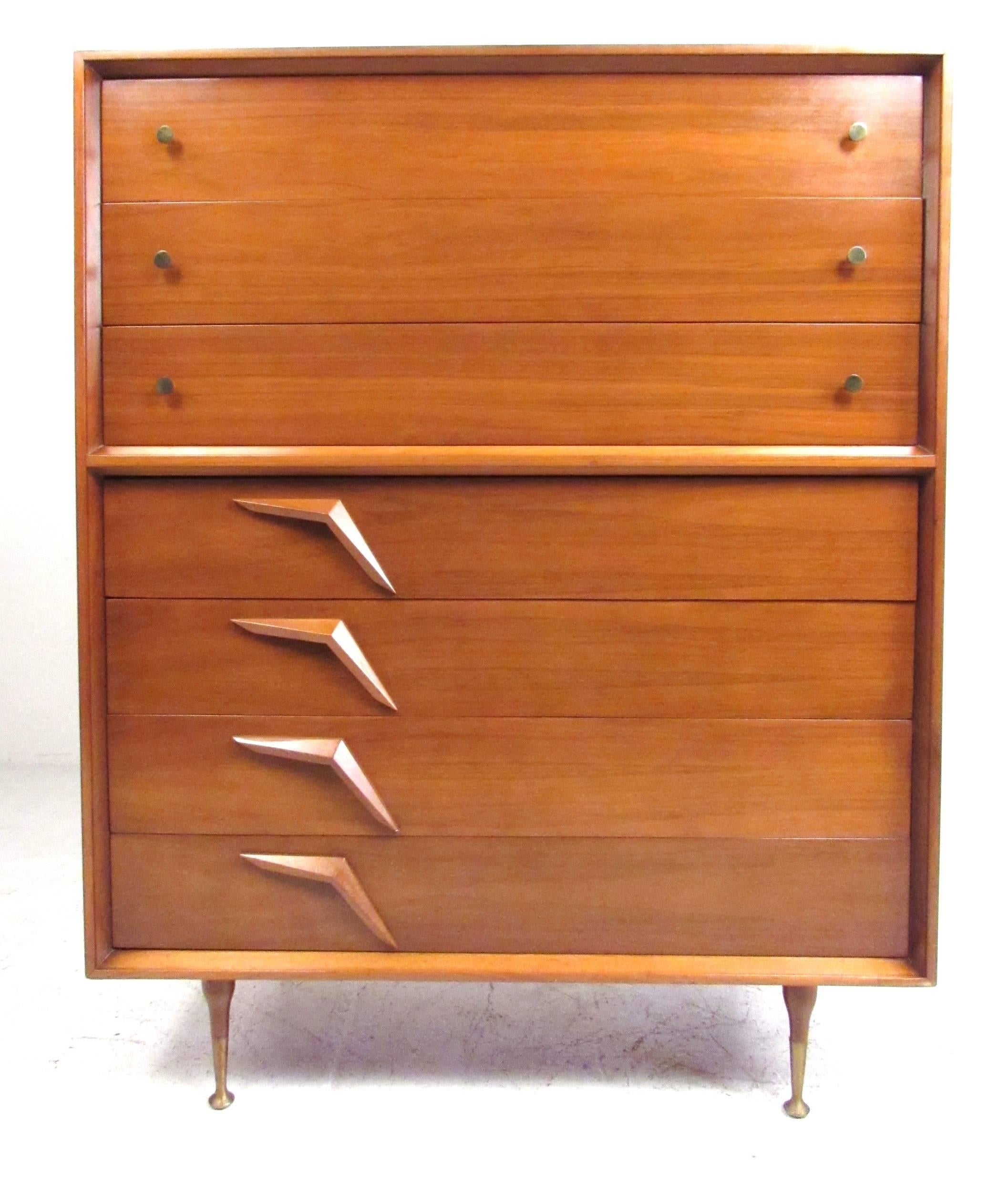 Attractive with ample storage, this 1950s highboy dresser features sculptural walnut drawer pulls with tapered legs and unique brass sabots. Quality construction details featuring oak drawers with metal glides and the original lacquer finish.