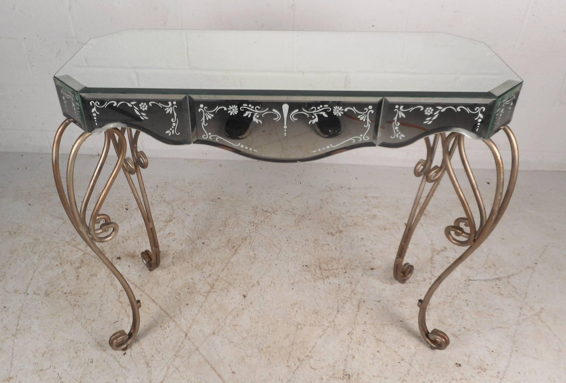 This gorgeous vintage modern hall table features sculptural mirrors all the way around with sleek bevelled edges. Unique design with white imprint designs on the sides and unusual metal legs with scroll detail. Sturdy and stylish table can be used