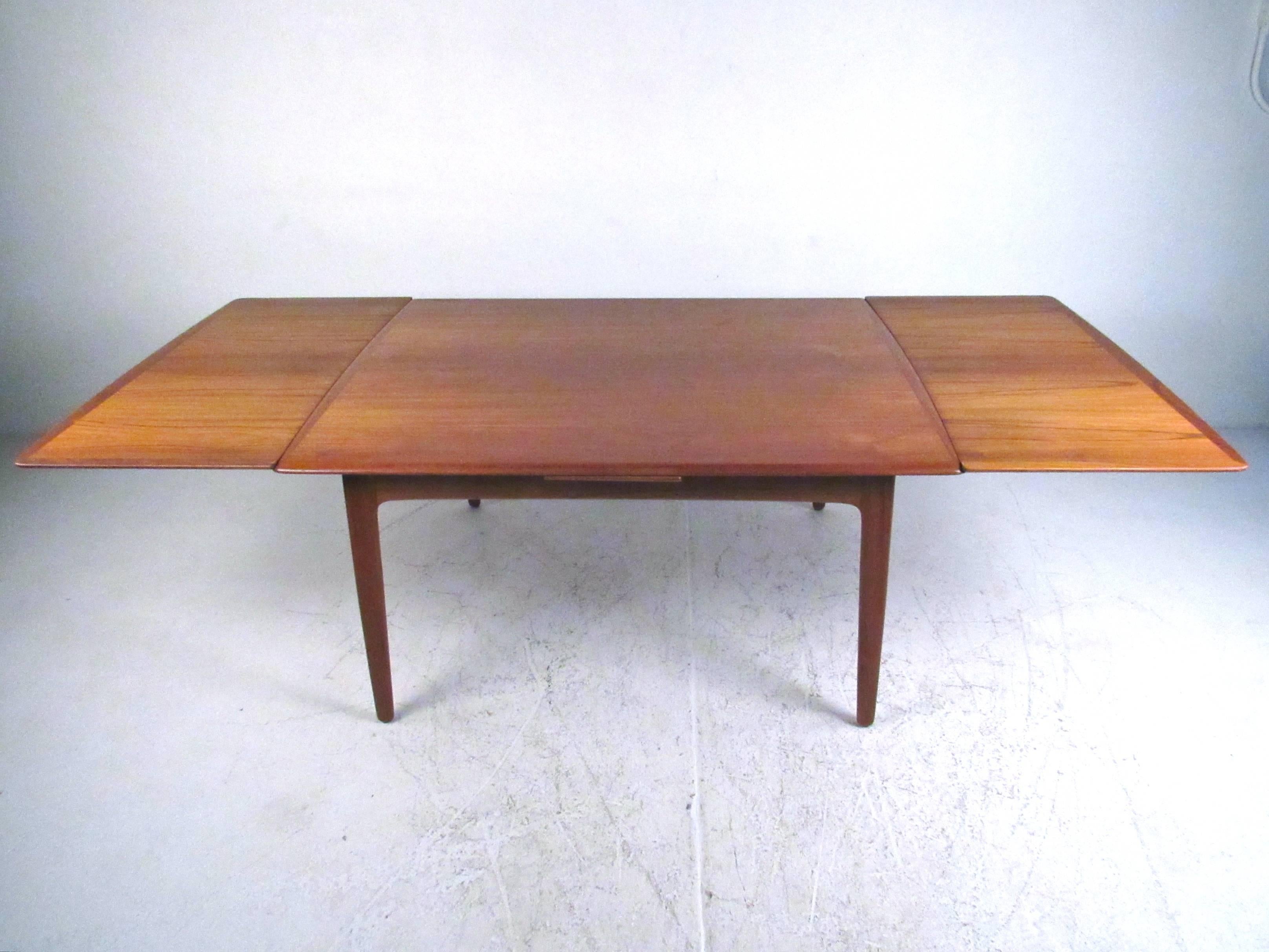 This uniquely sized teak dining table features quality construction, rich teak finish, and easily expands from 56 inches to one hundred inches wide. Draw-leaf Mid-Century style design makes this a versatile table perfect for any dining room or