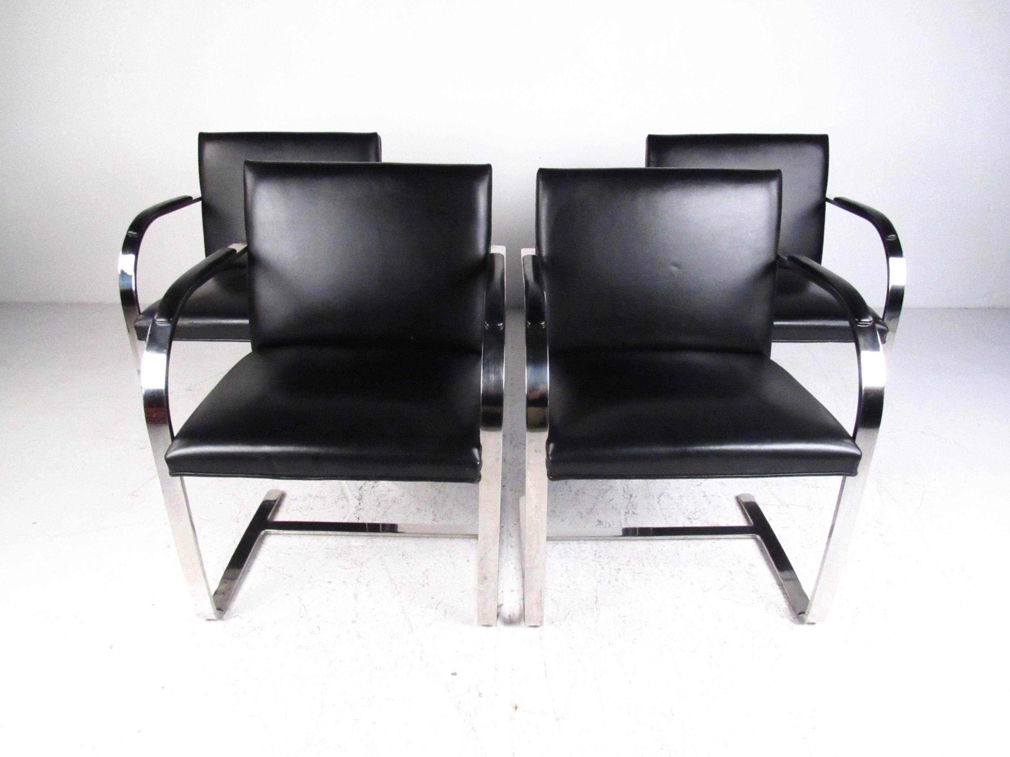 This stylish set of four arm chairs by Brueton make a stylish modern addition to any interior, from dining to conference room. Heavy stainless steel frame and vintage upholstery add to the charm of the set. Spacious proportions and padded arm rests