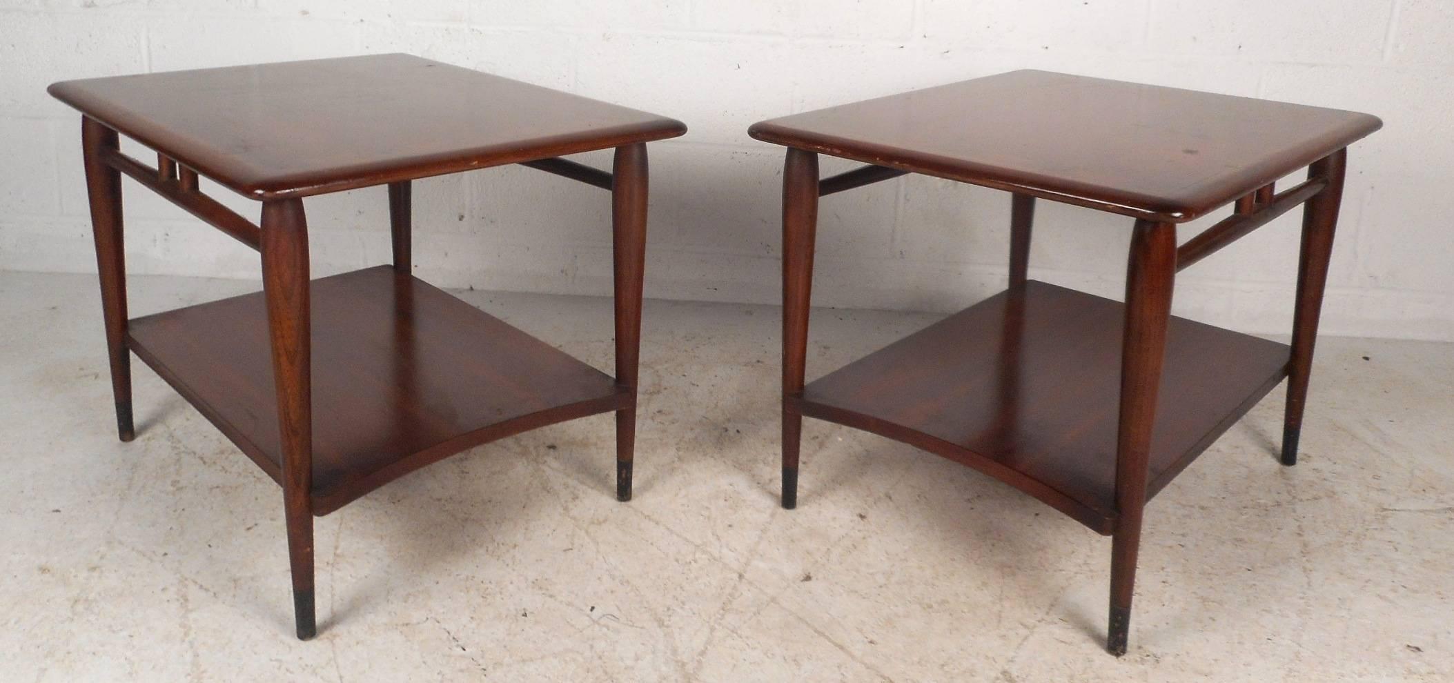 This gorgeous pair of vintage modern end tables feature a unique two-tone design with walnut and oakwood. Quality craftsmanship with spindle stretchers on each side and a curved lower shelf. Tapered legs, dovetail joints, and beautiful walnut wood