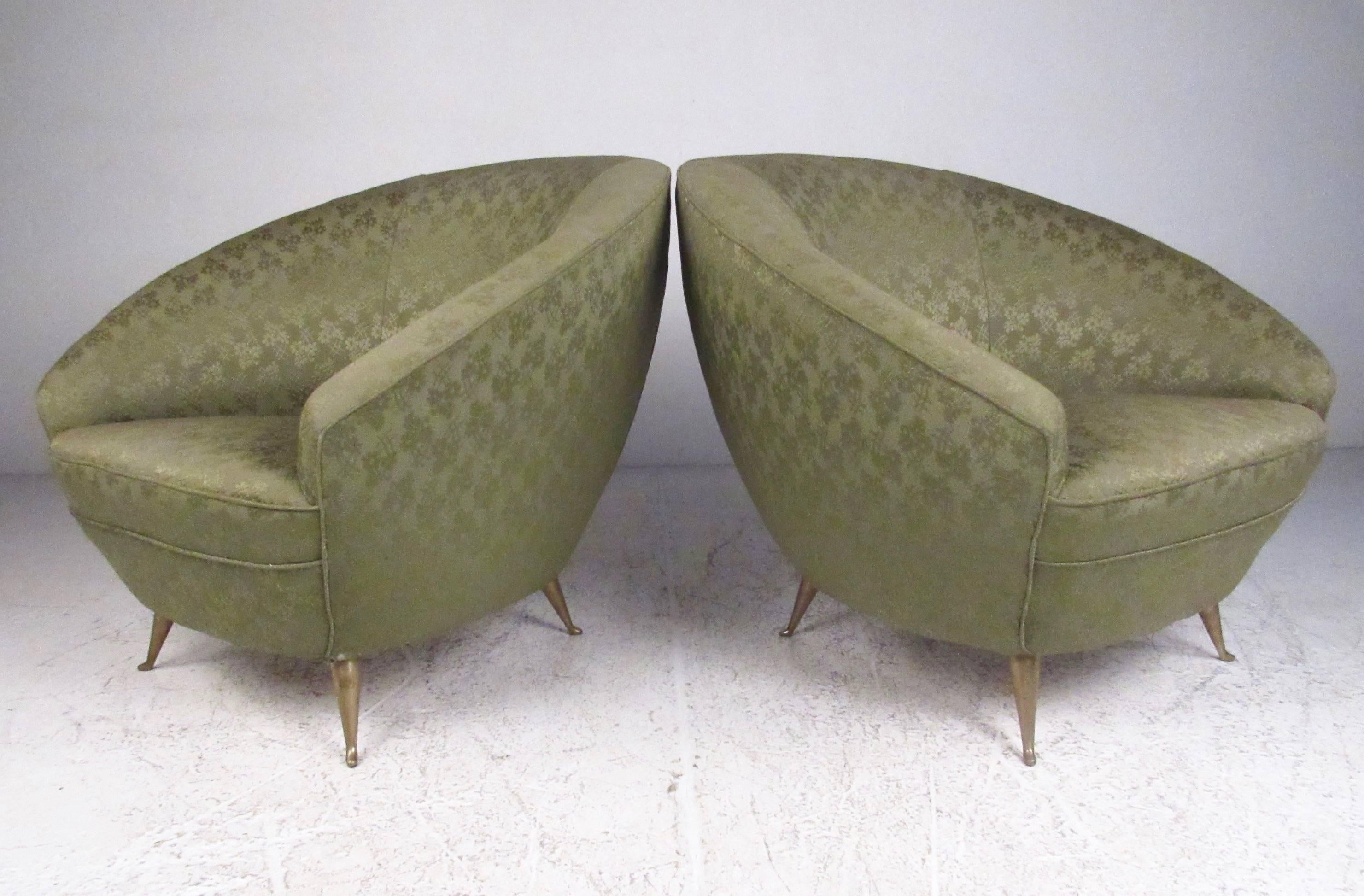 This vintage pair of Italian modern lounge chairs features elegant sculpted seats with stylish vintage upholstery. The unique and comfortable seat backs paired with tapered brass legs add to the Italian Modern design in the style of Ico Parisi.