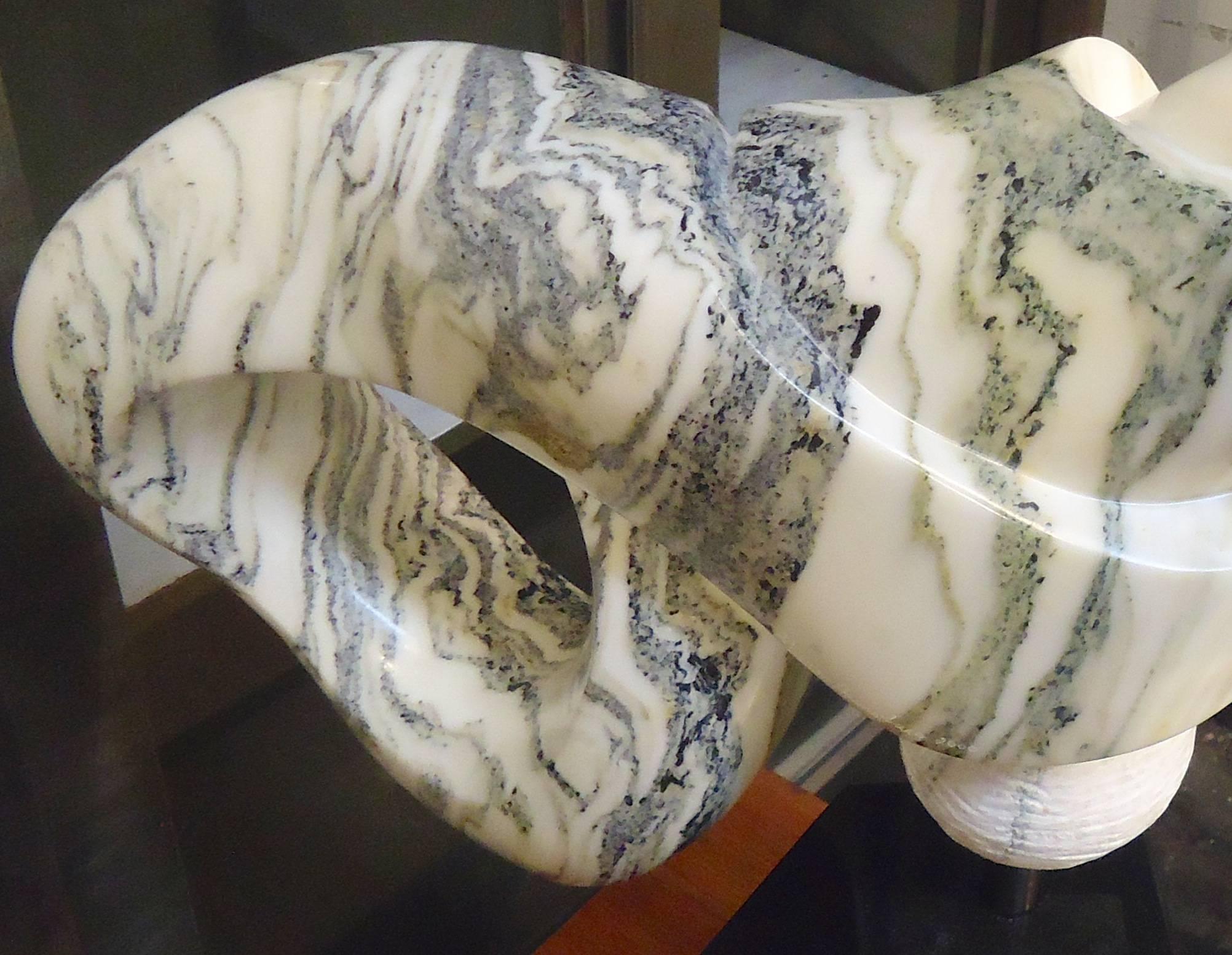 Wunderschönes gemeißeltes Marmorkunstwerk in Form einer Schleife oder eines Unendlichkeitssymbols. Signiert von der amerikanischen Künstlerin Sharon Gainsburg. Es handelt sich um eine sehr schwere Skulptur, die auf einem massiven schwarzen