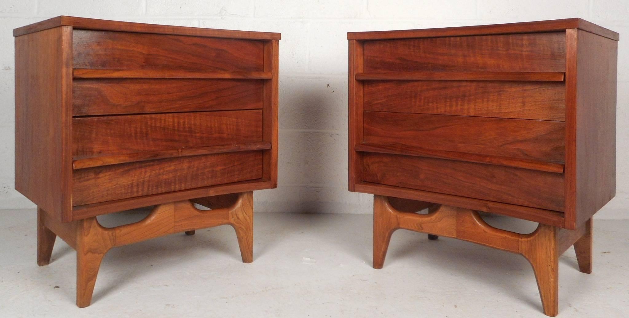 This beautiful pair of vintage modern nightstands feature an amazing curved front and a sculpted base. These newly refinished end tables have plenty of room for storage within there two large drawers. Stunning walnut wood grain and unusual drawer