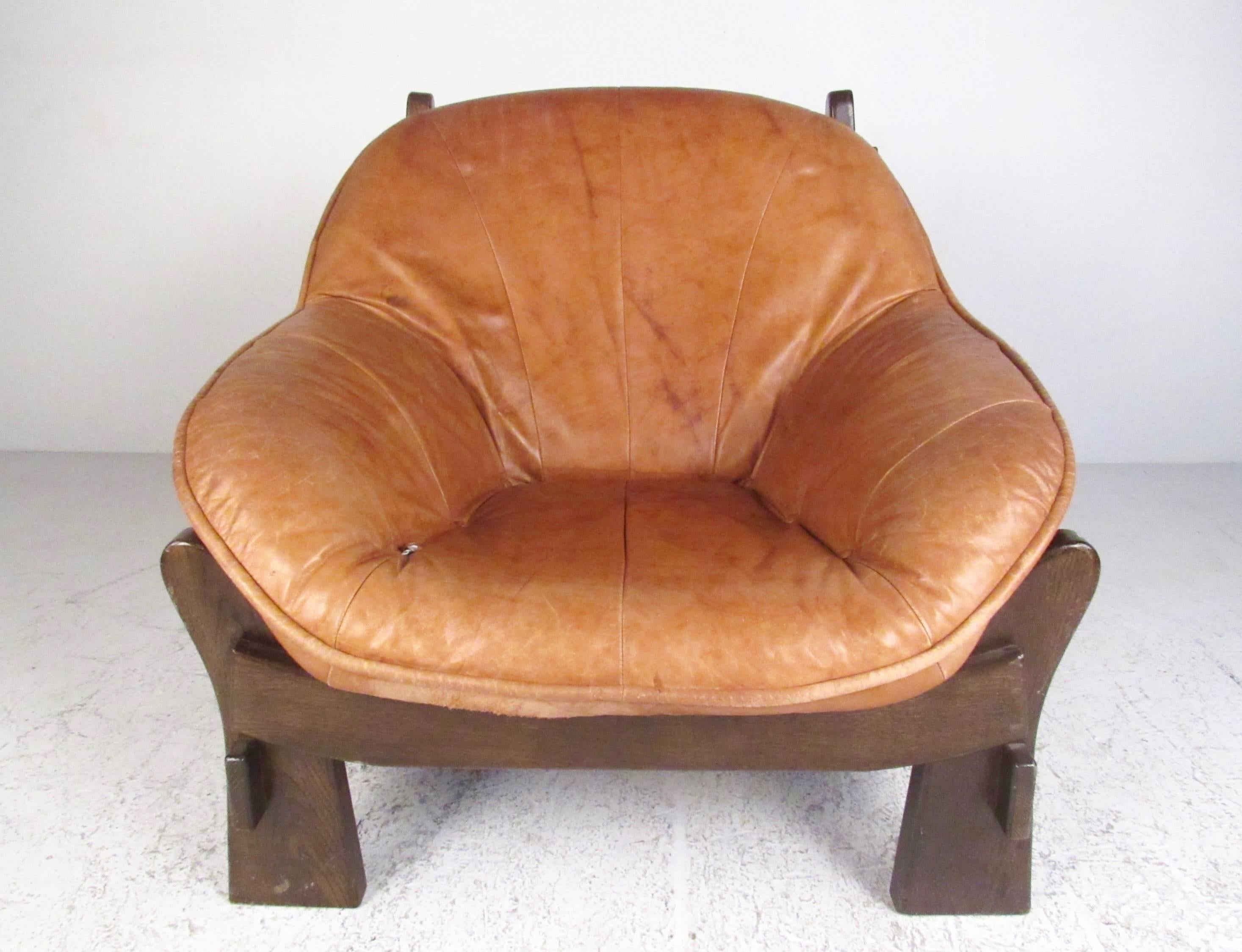 This vintage modern mix of comfort and mid-century style makes an impressive addition to any interior, and features plush leather upholstery and sturdy hardwood frame. Crafted in the Mid-Century style of Percival Lafer, this comfortable lounge chair