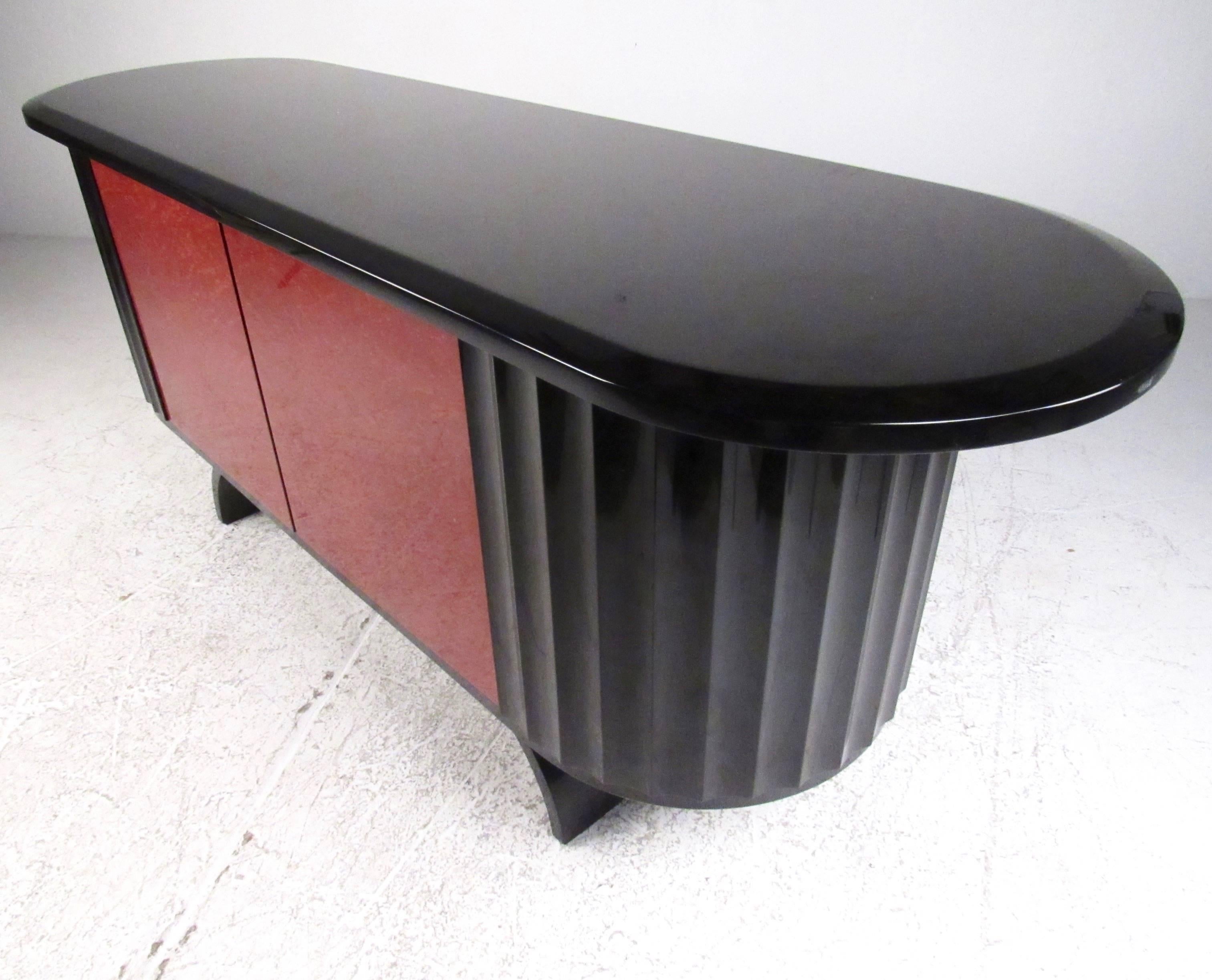 This stunning sculptural credenza features exotic wood doors with a gloss black lacquer finish. Unique base and fantastic shape make this storage cabinet the perfect modern deco addition to home or business. Please confirm item location (NY or NJ).