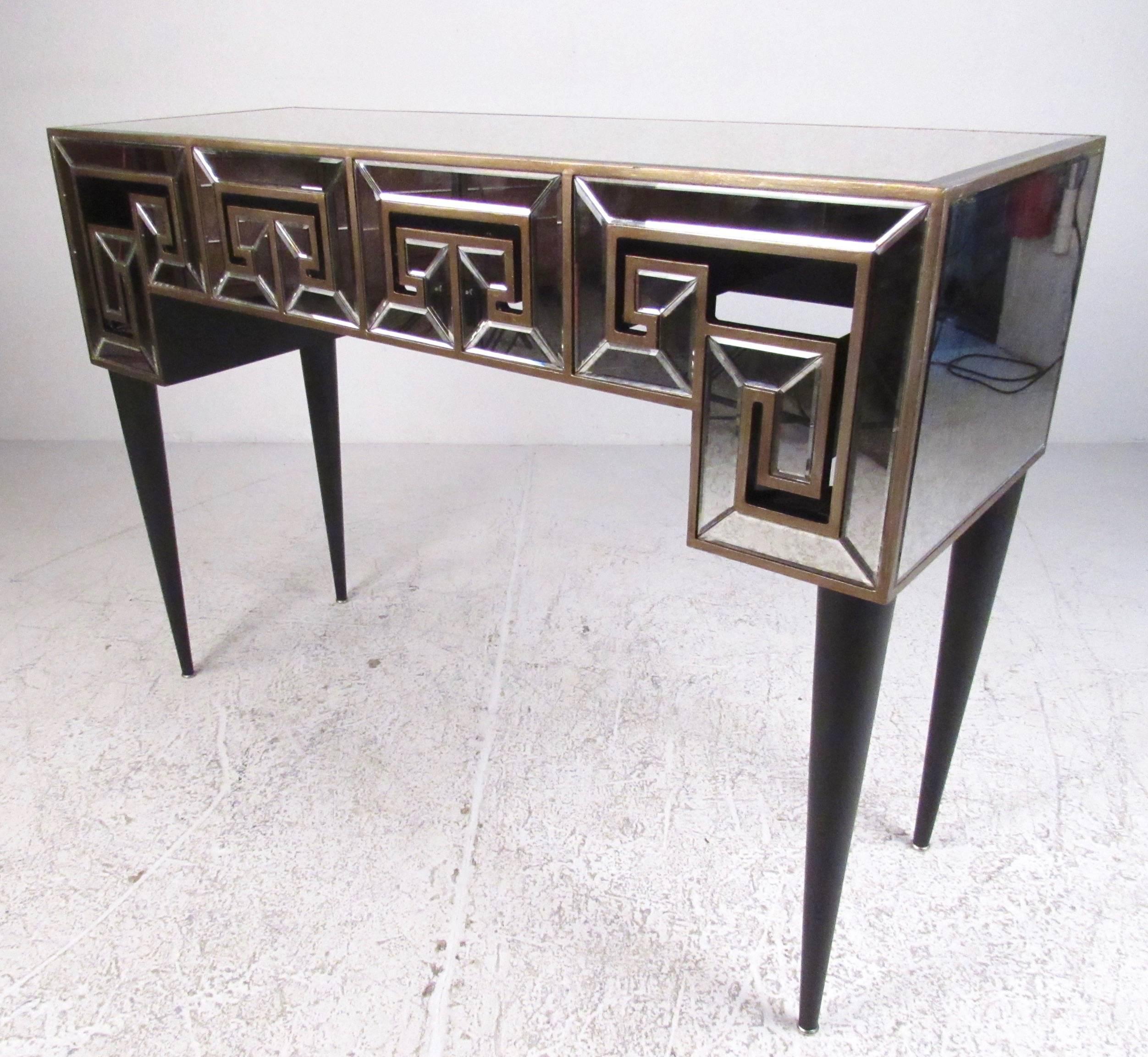 This stylish decorator style console table features beveled glass finish with Greek key style design. Stylish tapered legs, antiqued glass finish, and copper color trim add to the fantastic deco appeal, making this the perfect table for any