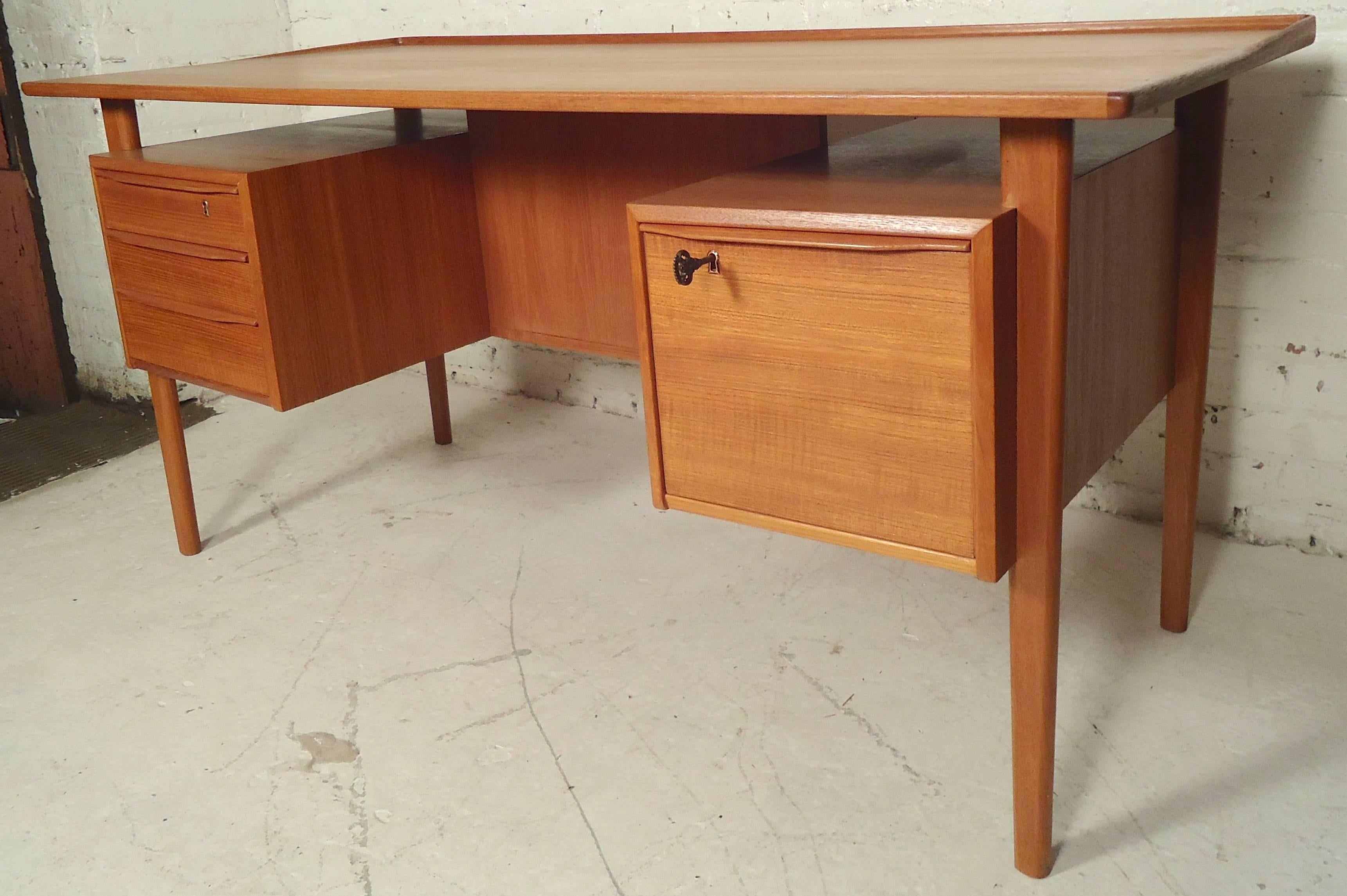 Mid-Century Modern teak desk by Peter Løvig Nielsen for Lovig Dansk with finished back. Features a floating top with curved trim, two banks of drawers, tapered legs, and handsome Danish modern style.
Kneehole: 23.5